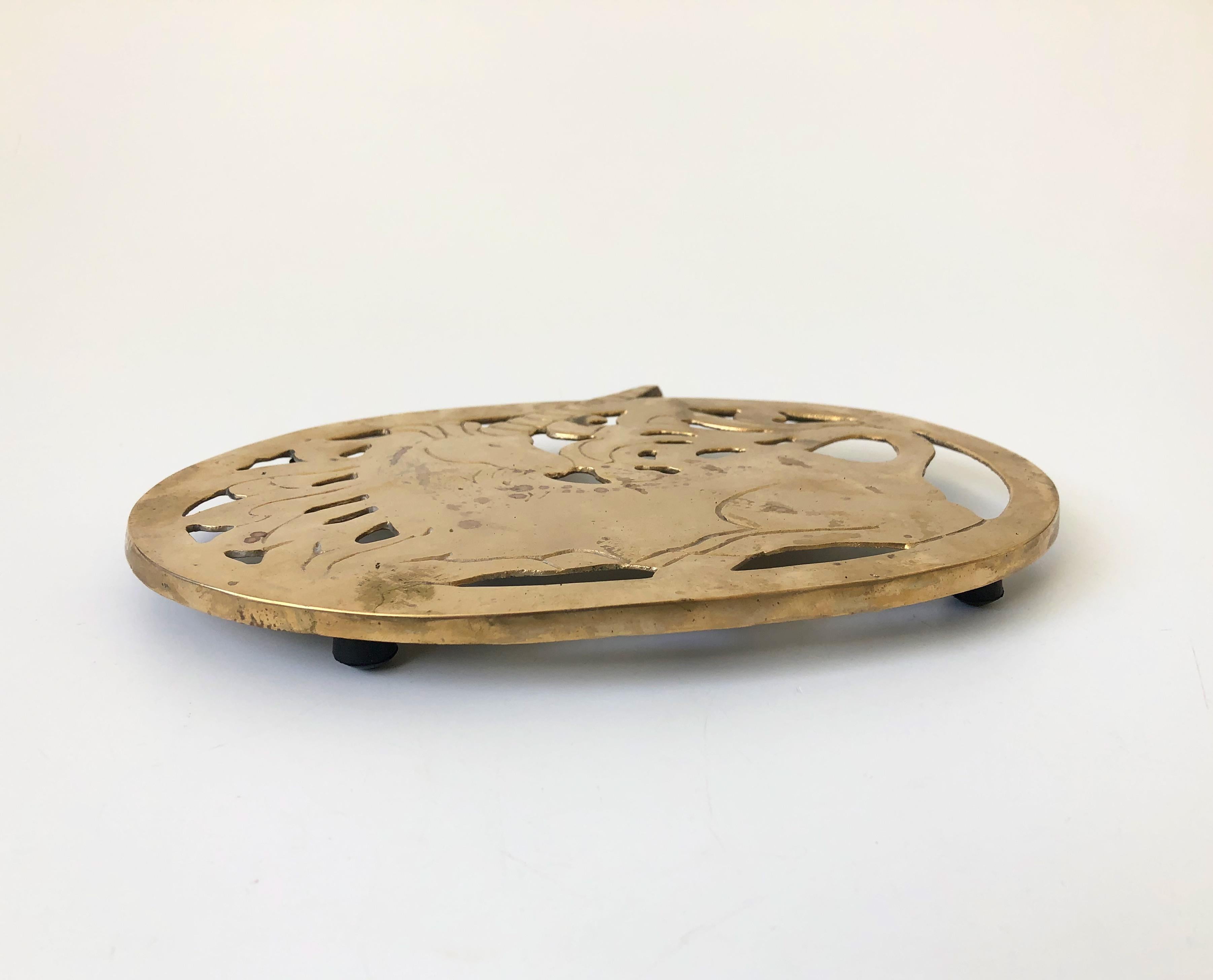 A beautiful oval brass trivet with the design of a unicorn. Perfect for keeping hot plates off of surfaces. Made in Taiwan by Knobler.
 