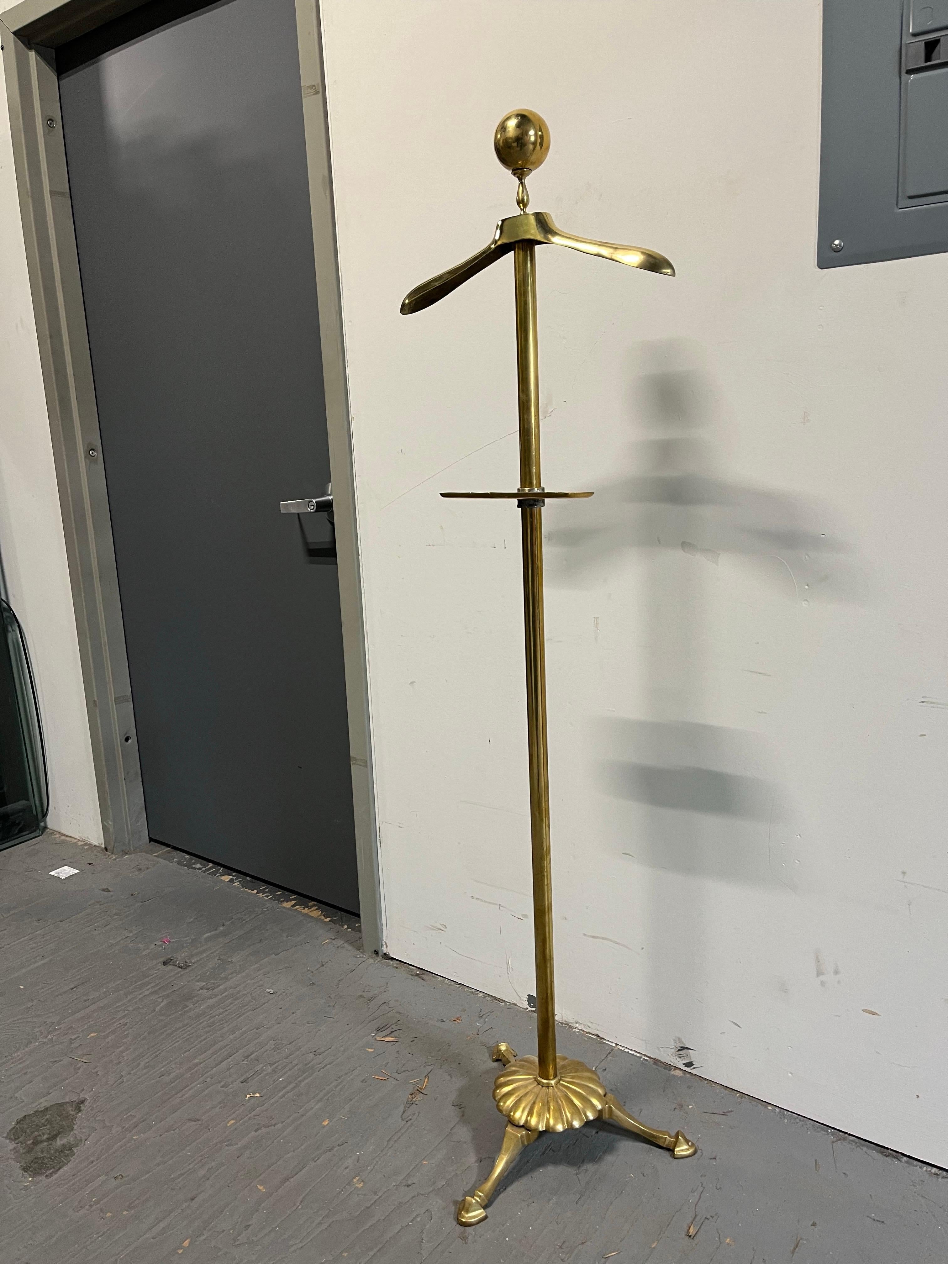 Dieser Garderobenständer aus massivem Messing besticht durch sein schlichtes, elegantes Design. Großer kannelierter Sockel mit Huffüßen, kleines geätztes Tablett zusammen mit breiter Garderobe, alles gekrönt mit einem wunderschönen Kugelkopf.