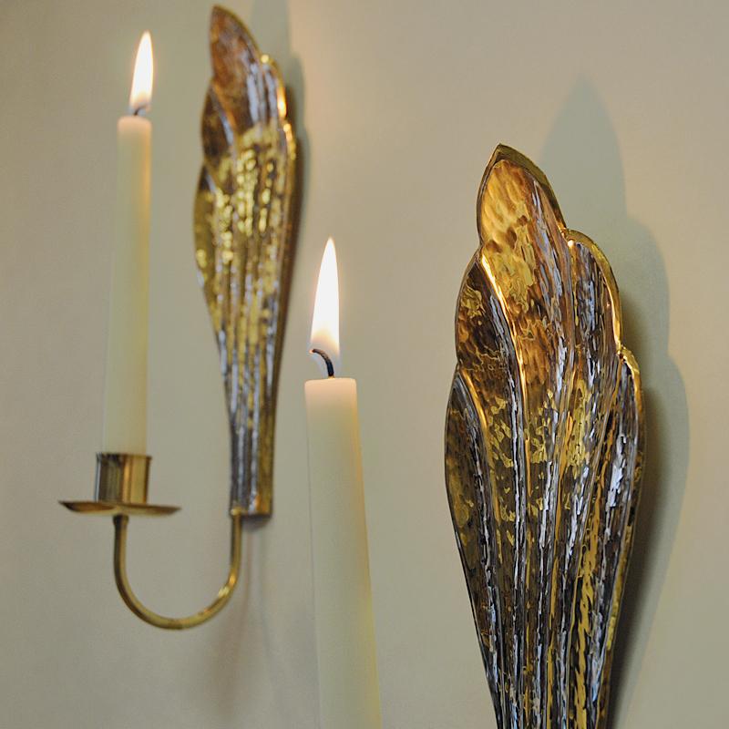 Very lovely midcentury brass candlestick holders shaped as two leaves by Swedish designer Lars Holmström, Arvika, Sweden, 1960s. The holders are for wall hanging and they give a nice shine when candles are lit. Stamp on the back with Lars Holmström,