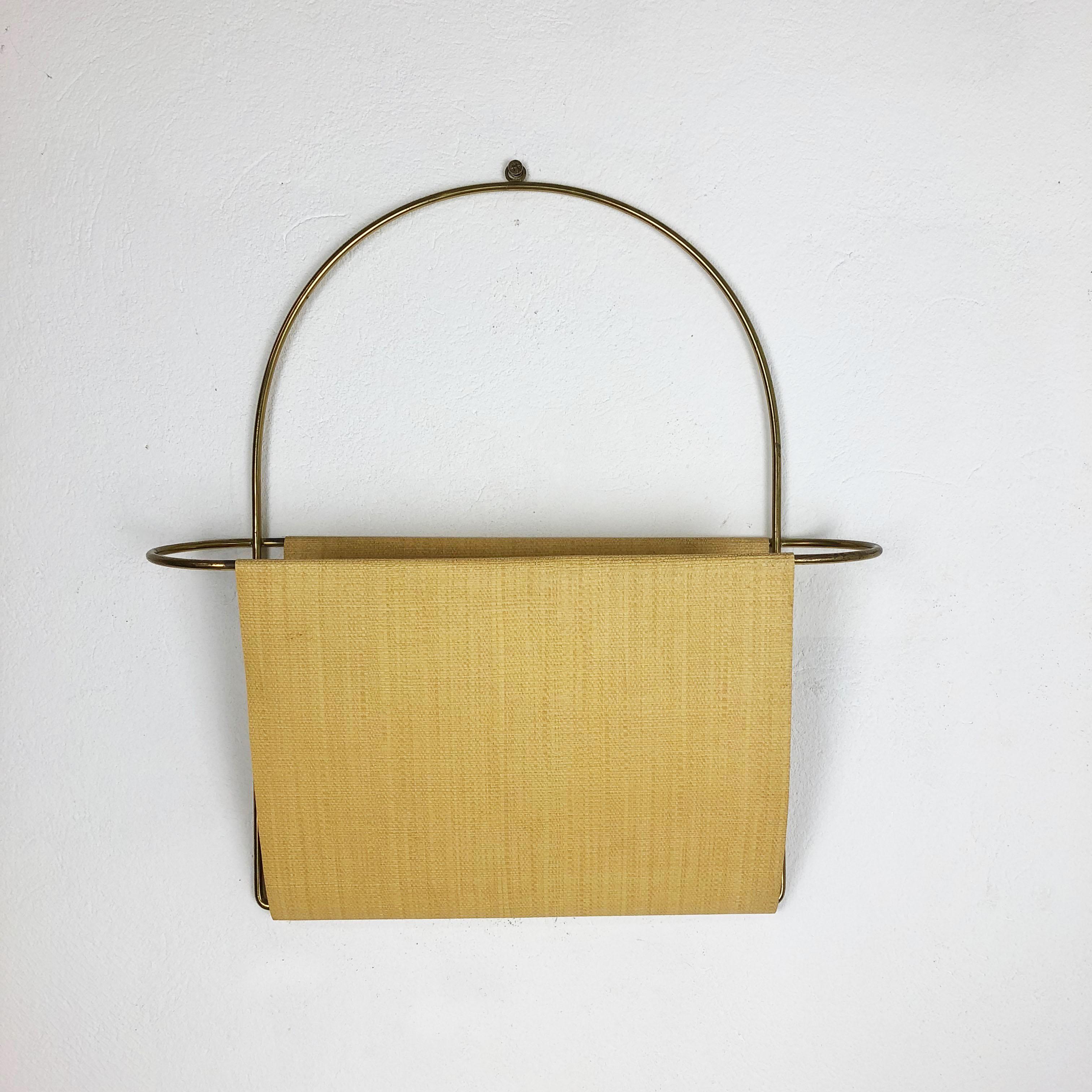 Article:

Wall magazine rack 

Origin:

Austria

Age:

1950s

Original vintage wall hanging magazine rack. This element was produced in the 1950s in Austria. The wall hanging and frame of this wall holder is made of brass, the storing compartment