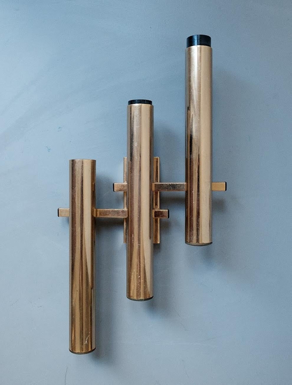 Exquisite vintage brass wall lamp designed by Gaetano Sciolari in the 1960s. This elegant piece features three arms each hosting a lightbulb, showcasing Sciolari’s signature blend of modernist design and luxurious materials. Gaetano Sciolari, an