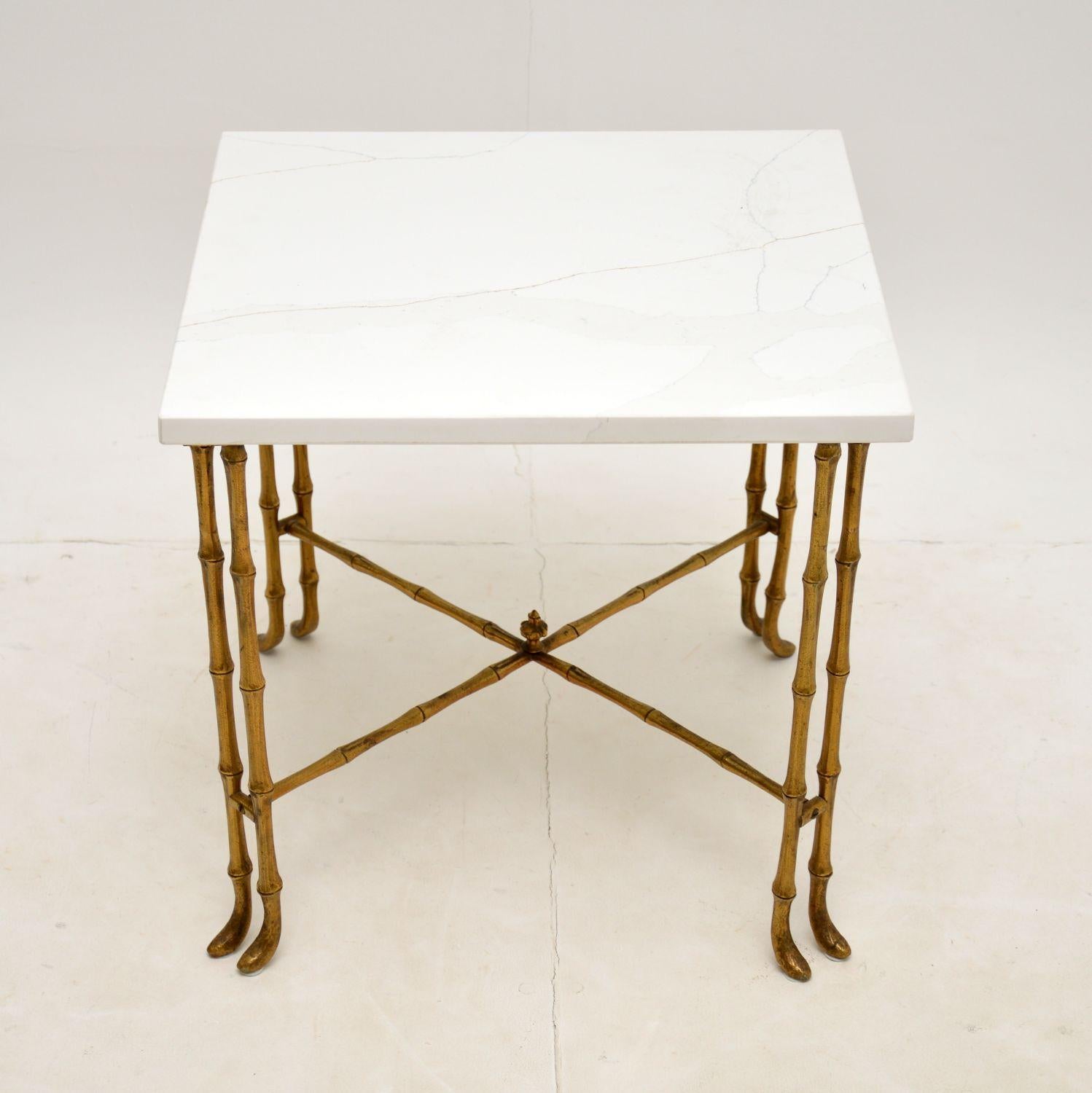 A gorgeous vintage solid brass side or coffee table, with a white quartz top. This was likely made in Italy, it dates from the 1960’s.

This has a lovely faux bamboo design, with eight legs supported by an X frame stretcher.

The frame is in