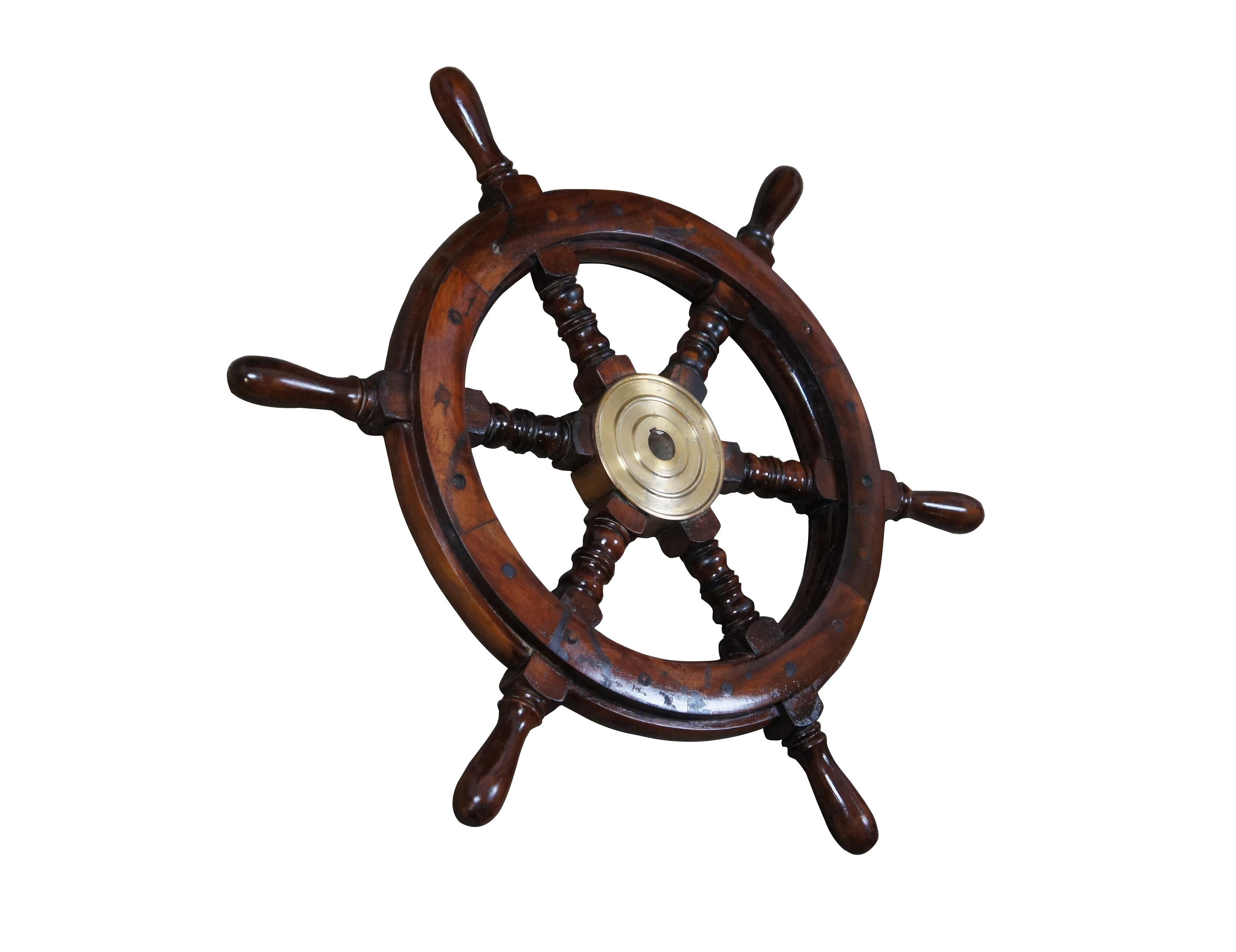 Late 20th century wood and brass ship's steering wheel / helm. Traditionally styled with six turned spokes and brass center mount.

Dimensions:
24