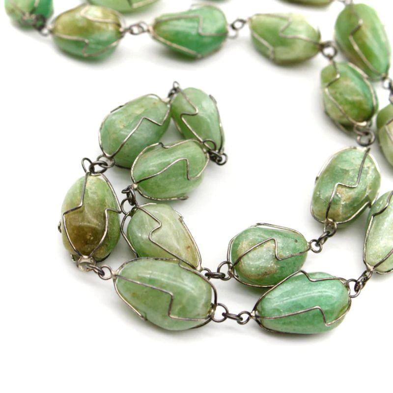 Brazilian Sterling Silver Wire-Wrapped Aventurine Necklace, circa 1960's

Circa the 1960’s, this is a bold sterling silver wire-wrapped necklace from São Paolo, Brazil. It contains 40 aventurine stones, in varying shades of light green, many of