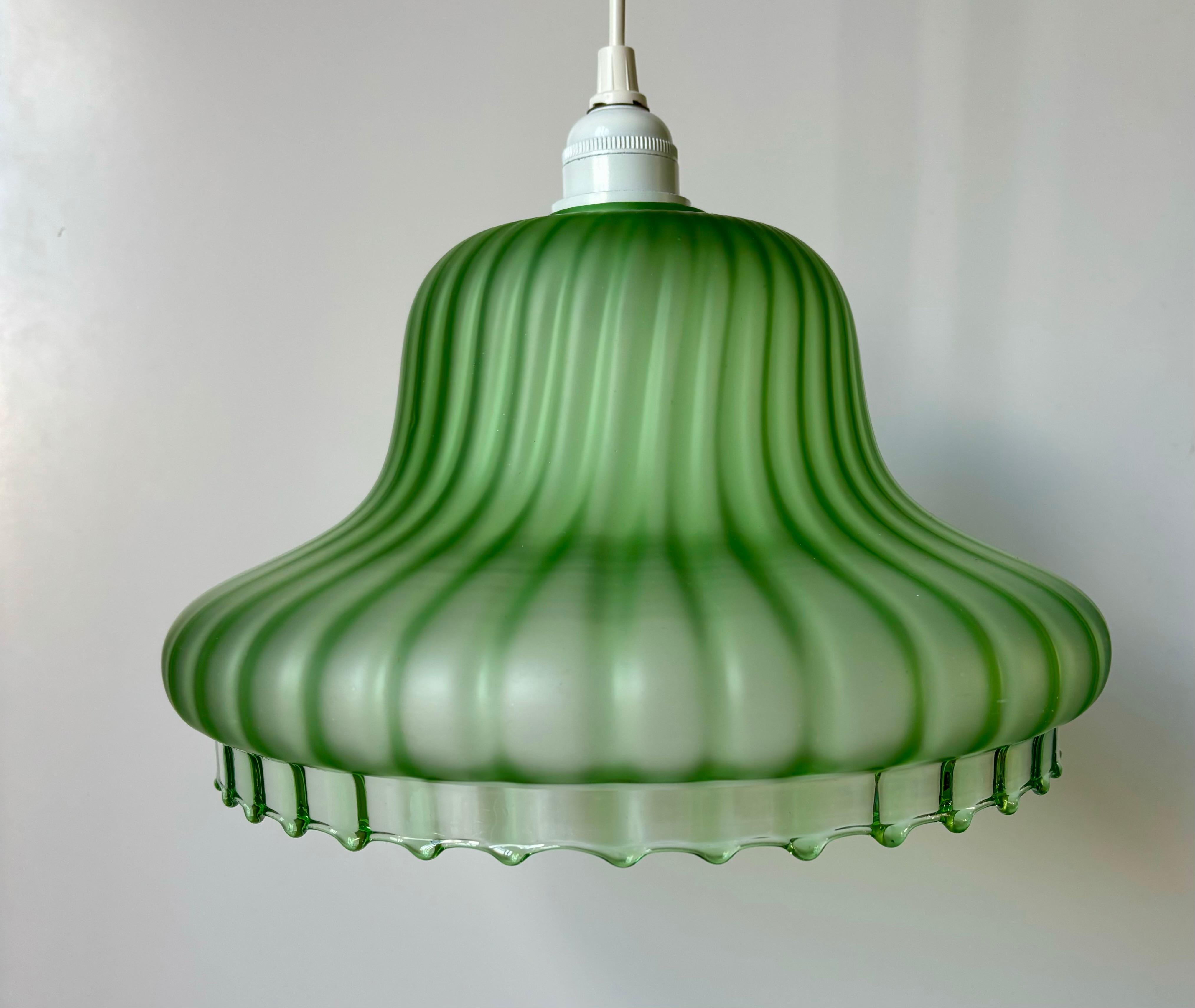 Striking translucent absinthe green European mid-century modern blown art glass open base pendant. Striped pattern from top to base ending in small rounded tips along the edge. In the style of Murano, Kosta Boda, Helena Tynell and Kalmar. Wired for