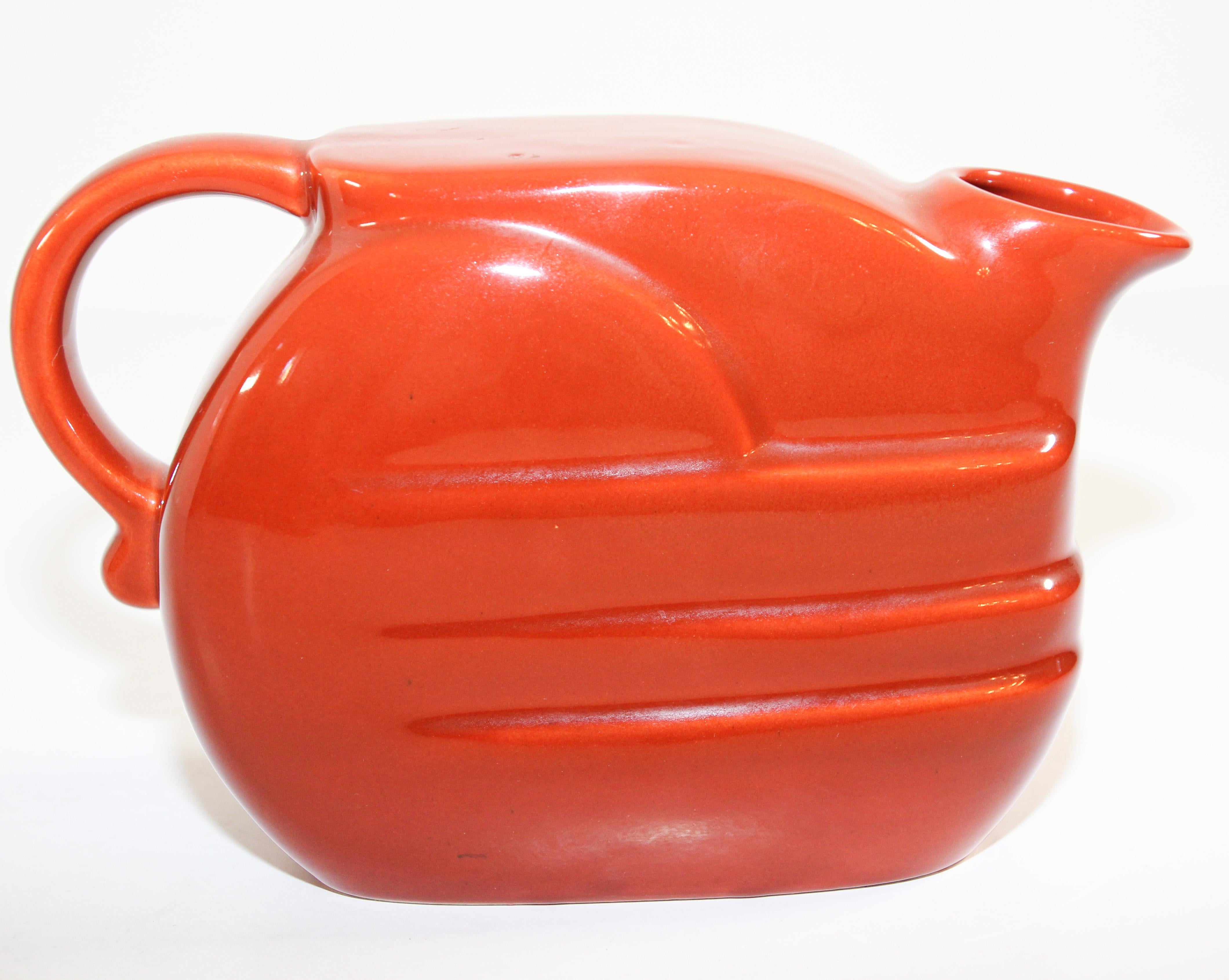 Midcentury vintage bright orange pitcher designed in the 1960s by Joseph Magnin.
Vivid Italian pottery glazed orange retro barware pitcher with handle in a modern stylized form.
The ceramic pitcher was handmade in Italy for the legendary Joseph
