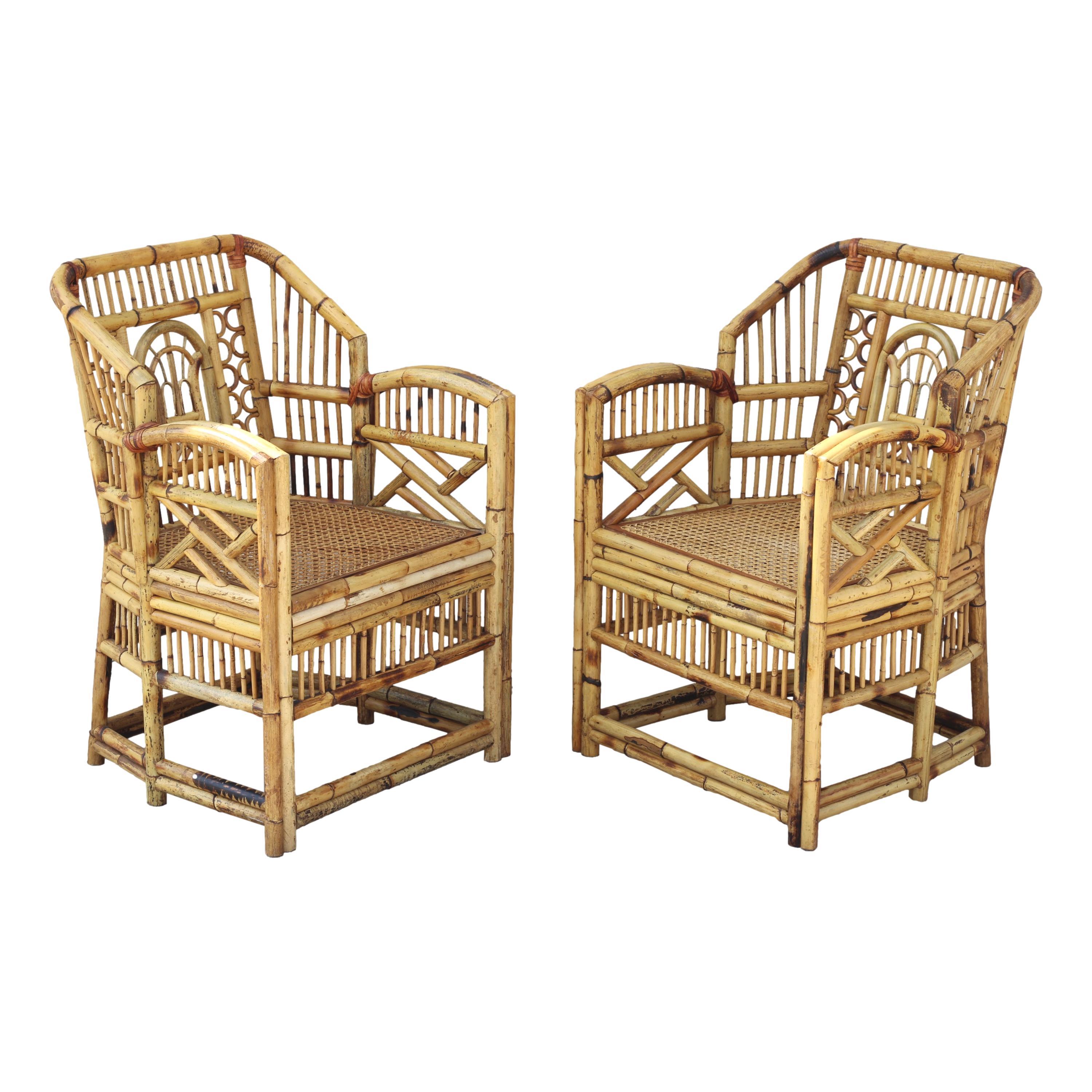 Fabulous set of four vintage Brighton style bamboo dining armchairs, circa 1970.  These handcrafted Chinese Chippendale chairs feature caned-bottom seats, bamboo open fretwork, and a burnt bamboo finish with a lovely distressed aged patina. Seat