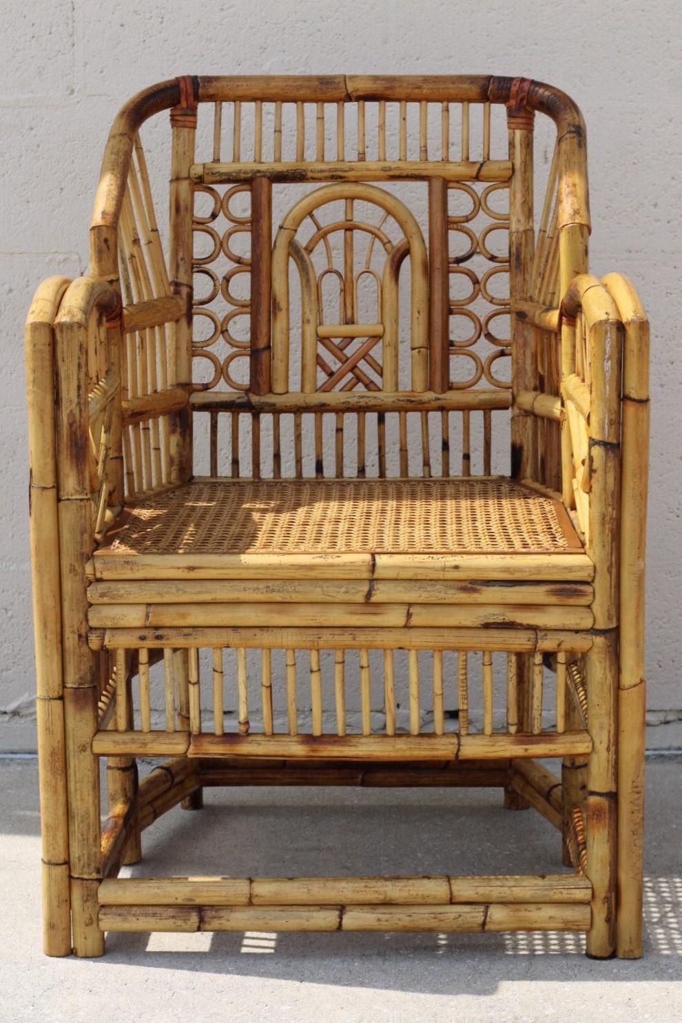 Brighton style bamboo dining arm chair, circa 1970.  This handcrafted Chinese Chippendale chair features a caned-bottom seat, bamboo open fretwork, and a burnt bamboo finish with a lovely distressed aged patina. Small loss (one small stick of