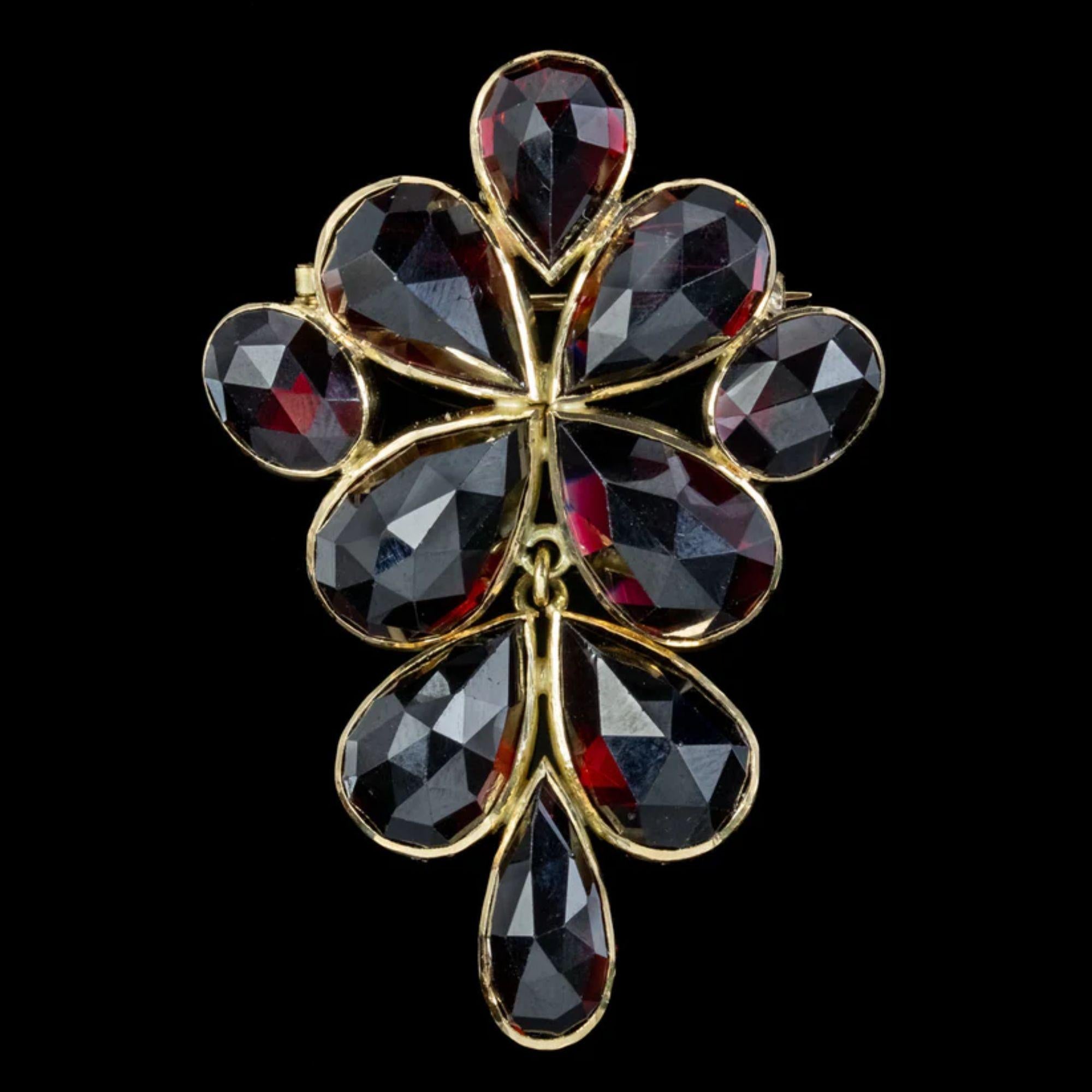 A remarkable vintage brooch adorned with ten briolette cut almandine garnets that display a blazing cherry-red fire beneath their dark surface. The stones range from 3ct to 6ct and glisten with many expertly cut, triangular facets. 

The 14ct gold