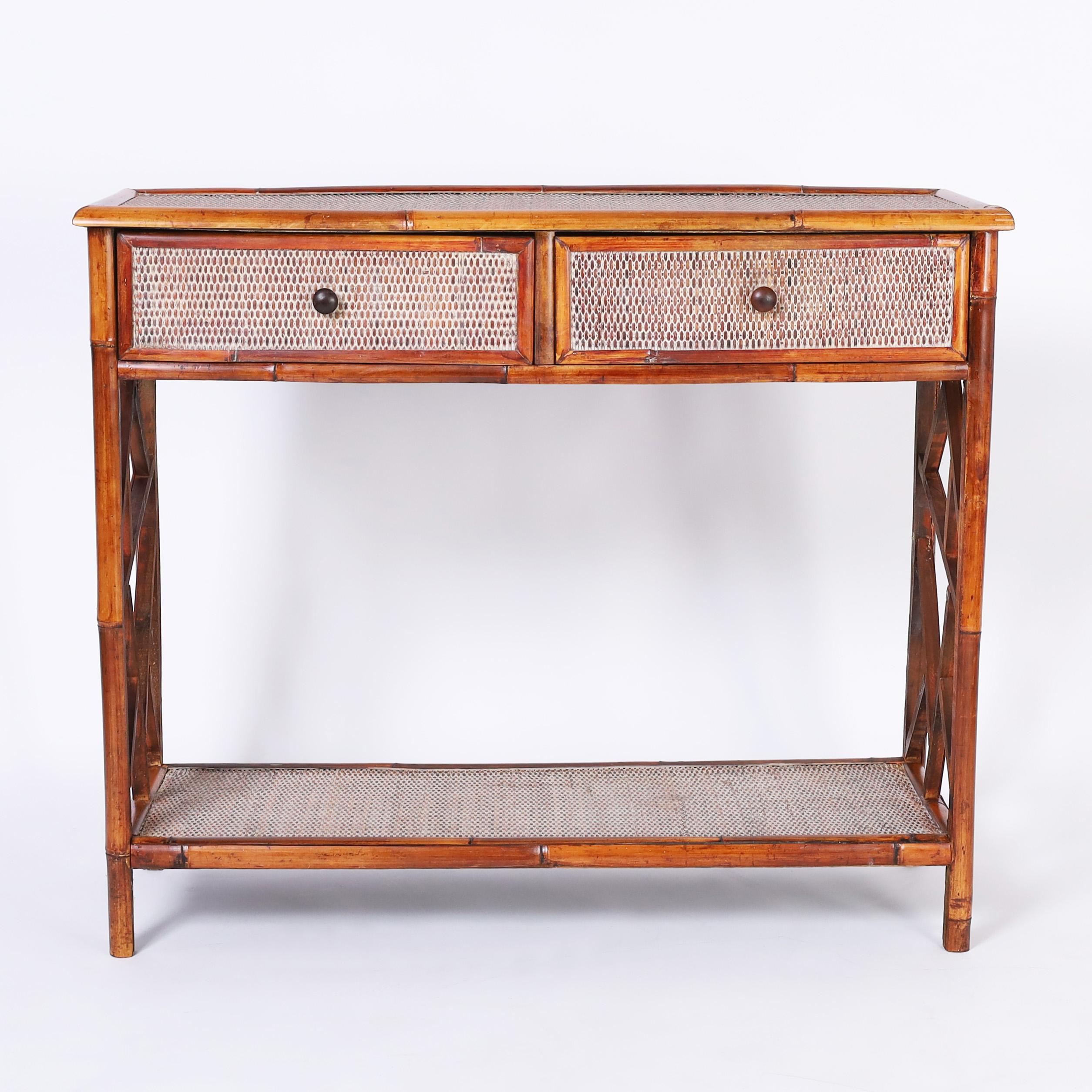 Handsome British Colonial style server or console crafted in bamboo with grasscloth panels on two tiers with a two drawer case and featuring Chinese chippendale motifs on the sides.