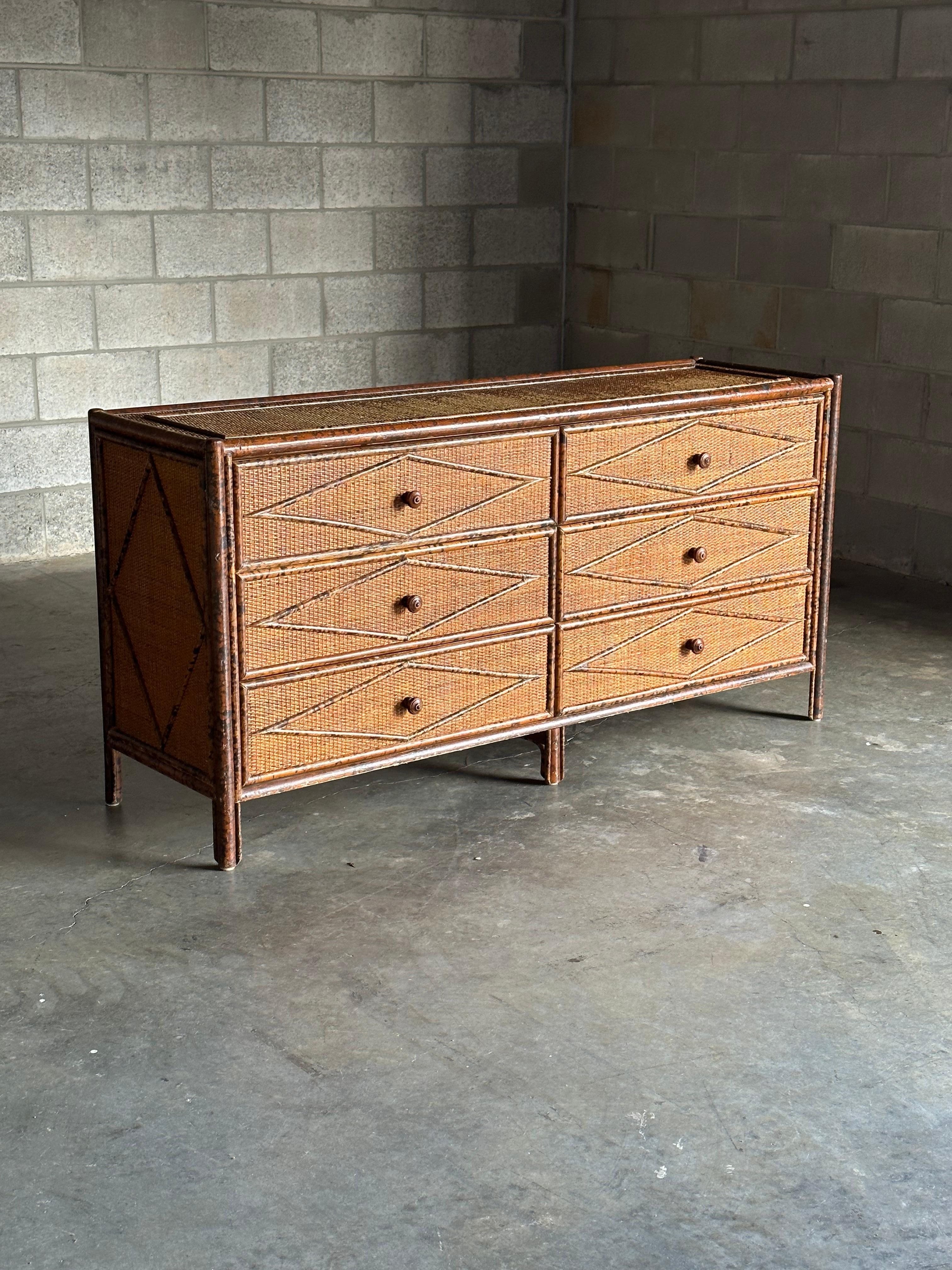 Vintage British colonial style dresser inbamboo and rattan. Six spacious drawers clad in rattan with a bamboo skeleton. Wonderful diamond pattern throughout. Would work in a variety of interiors. Design is attributed to Ralph Lauren, would also work