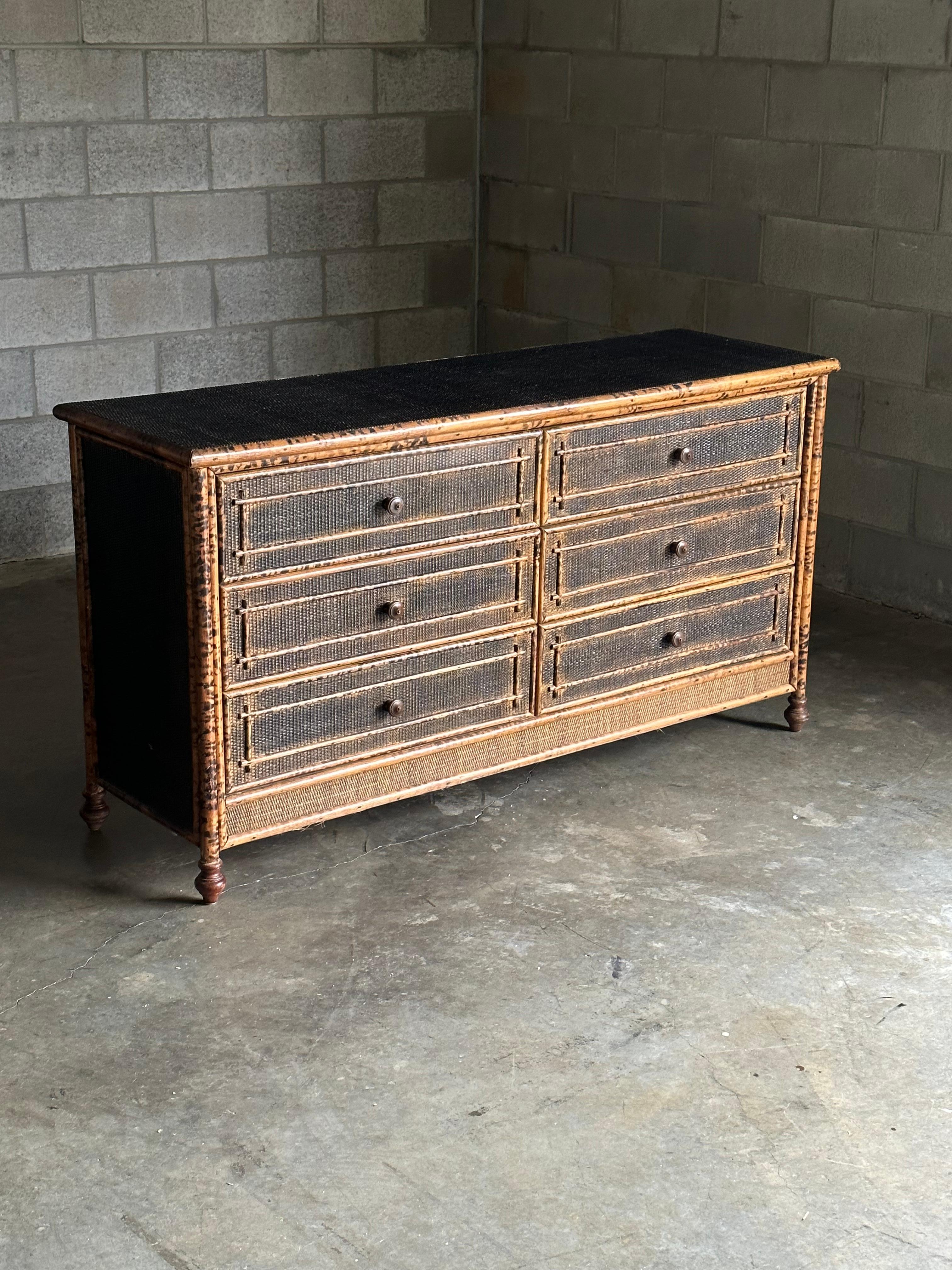 Vintage British colonial style dresser in bamboo and rattan. Two spacious drawers clad in rattan with a bamboo skeleton. Wonderful geometric pattern throughout. Would work in a variety of interiors. Design is attributed to Ralph Lauren for