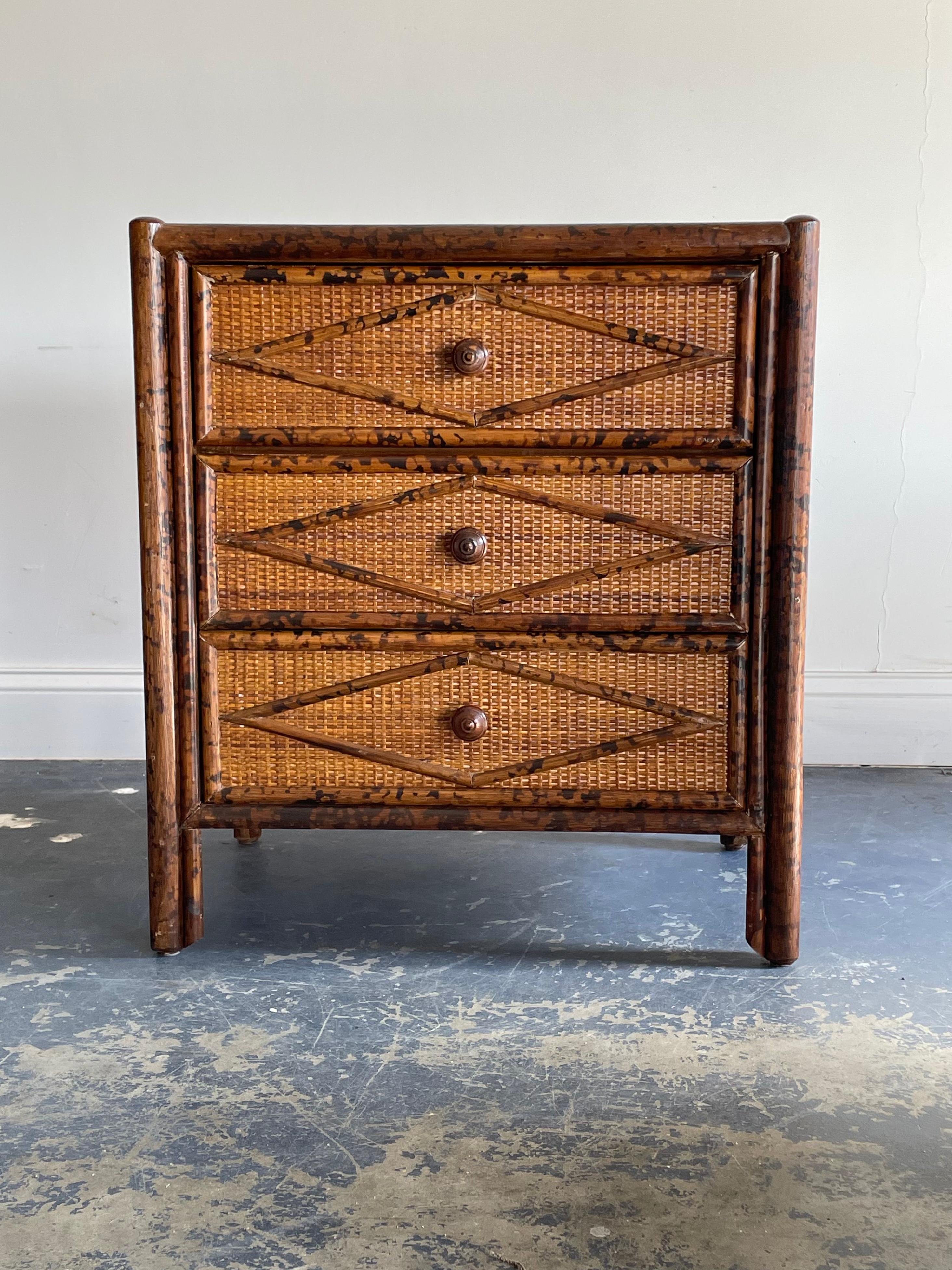 Vintage British colonial style chest in bamboo and rattan. Three spacious drawers clad in rattan with a burnt or tortoise bamboo skeleton. Wonderful diamond pattern throughout.