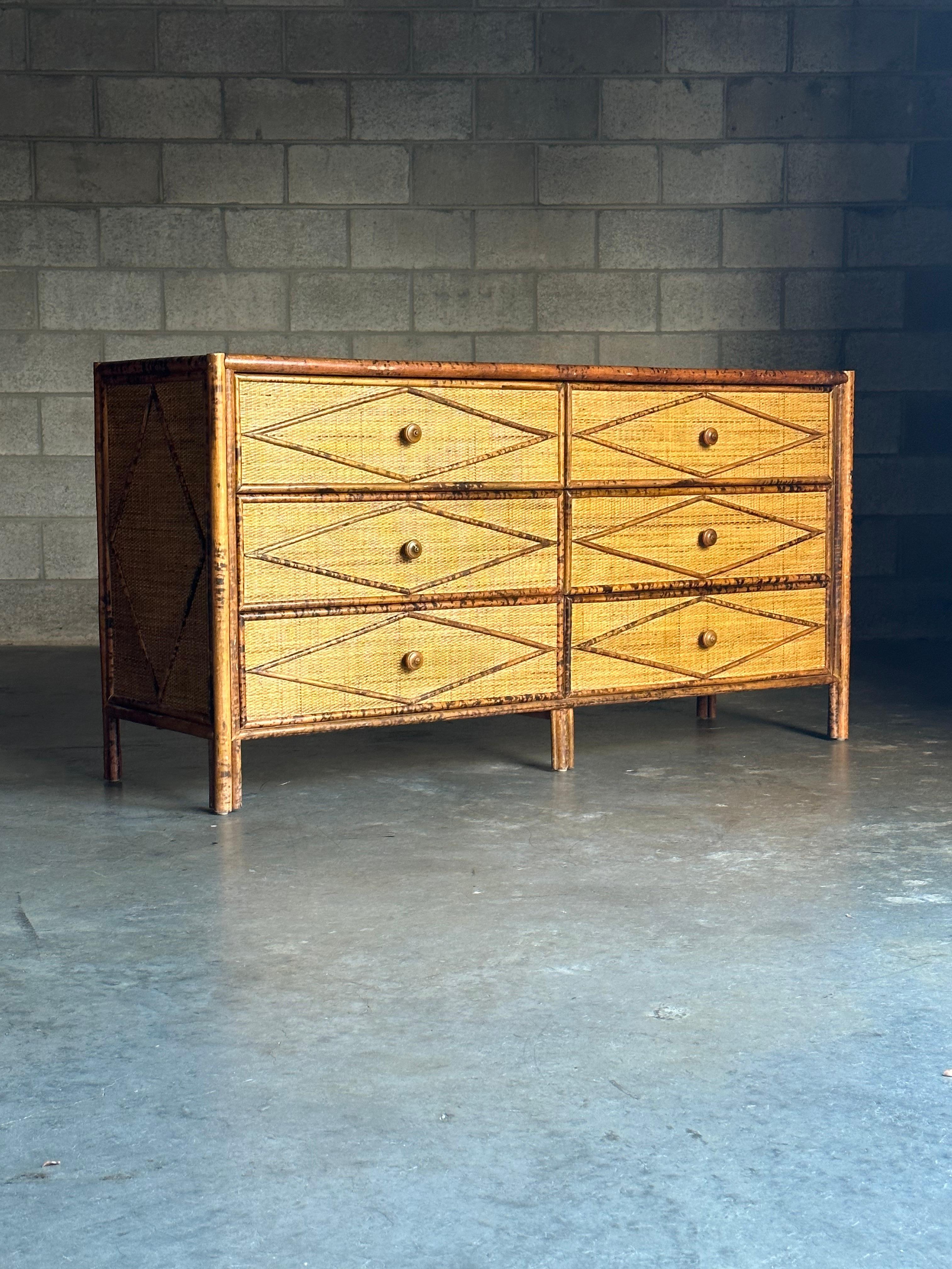 Vintage British colonial style dresser in bamboo and rattan. Six spacious drawers clad in rattan with a bamboo skeleton. Wonderful diamond pattern throughout. Sold through Bloomingdales in the 1980-1990s and attributed to Ralph Lauren, this dresser