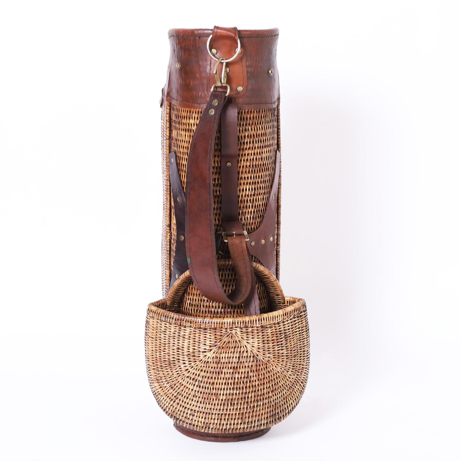 Transporting British Colonial style golf bag crafted in wicker and leather in a vintage form for golf clubs, balls and tees.