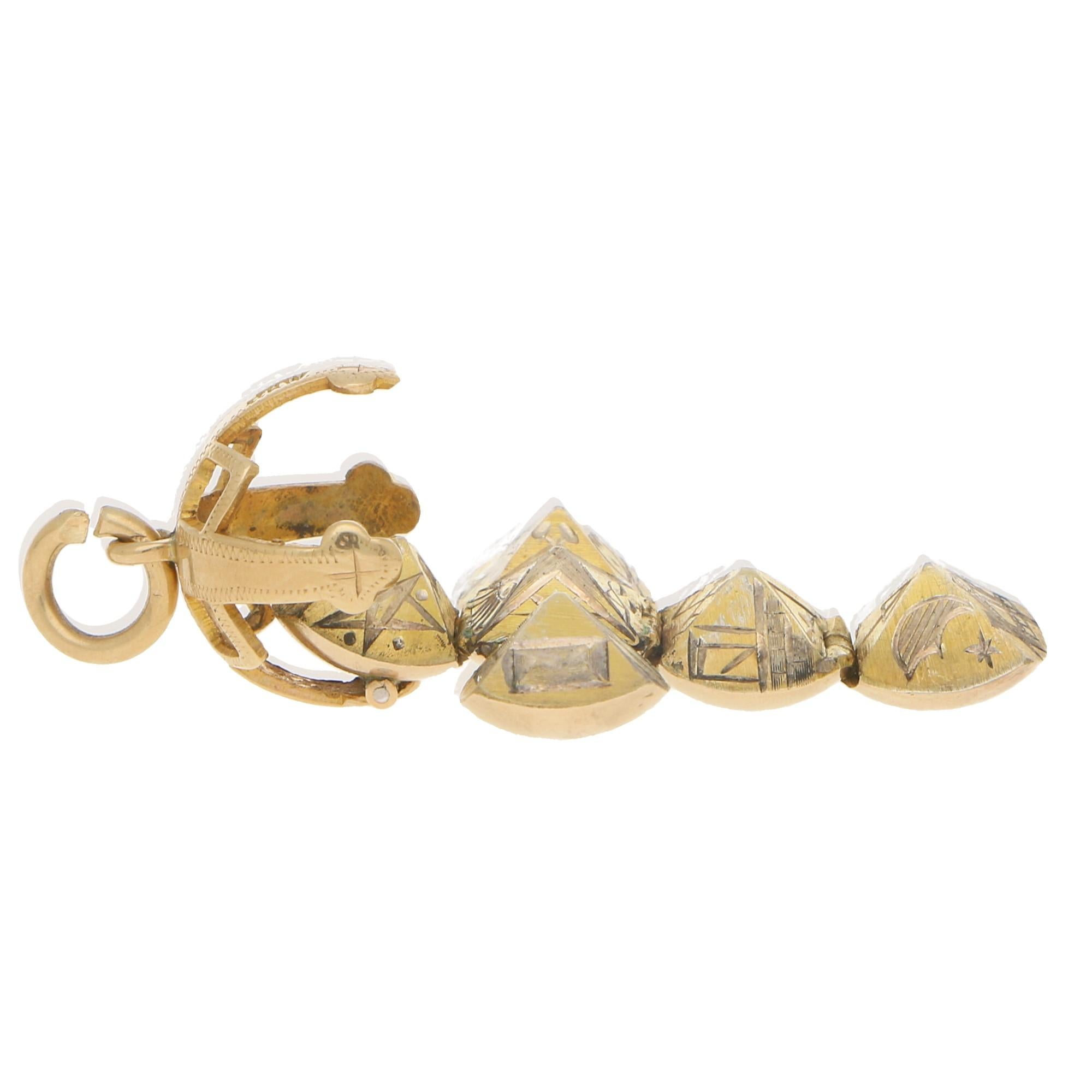 A very unusual and highly collectible British Masonic Orb ball charm set in 9k yellow gold and silver. This highly unique piece opens to reveal beautifully hand engraved equally sized pyramids, there are 6 pyramids in total and 24 masonic symbols (4