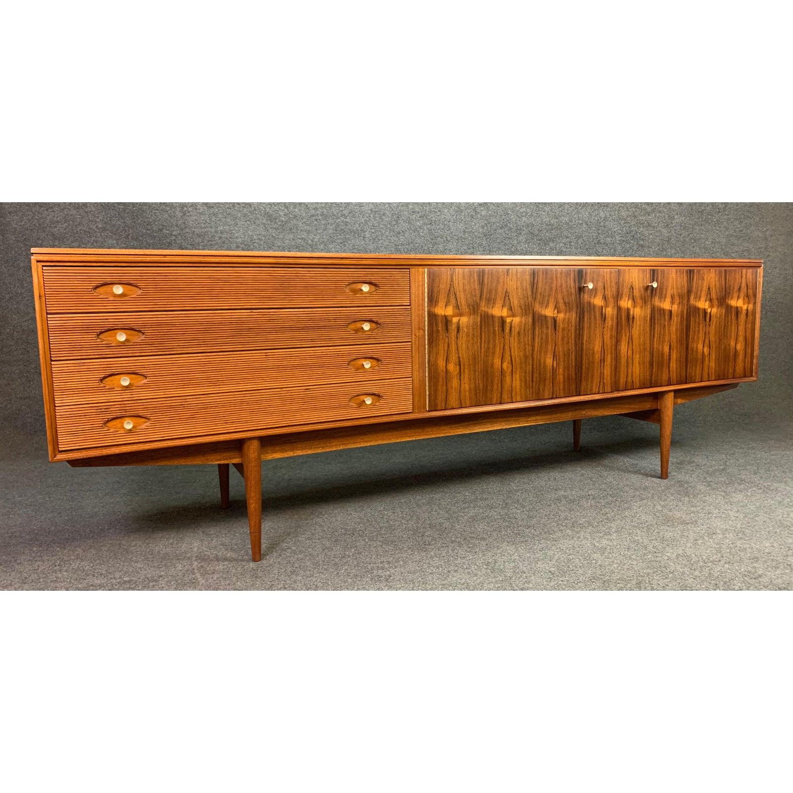 Here is an exclusive sideboard by master designer Robert Heritage manufactured by Archie Shine in UK in the 1960s.
This long sideboard, recently imported from UK to California before its restoration, features a vibrant wood grain, a raised edge on