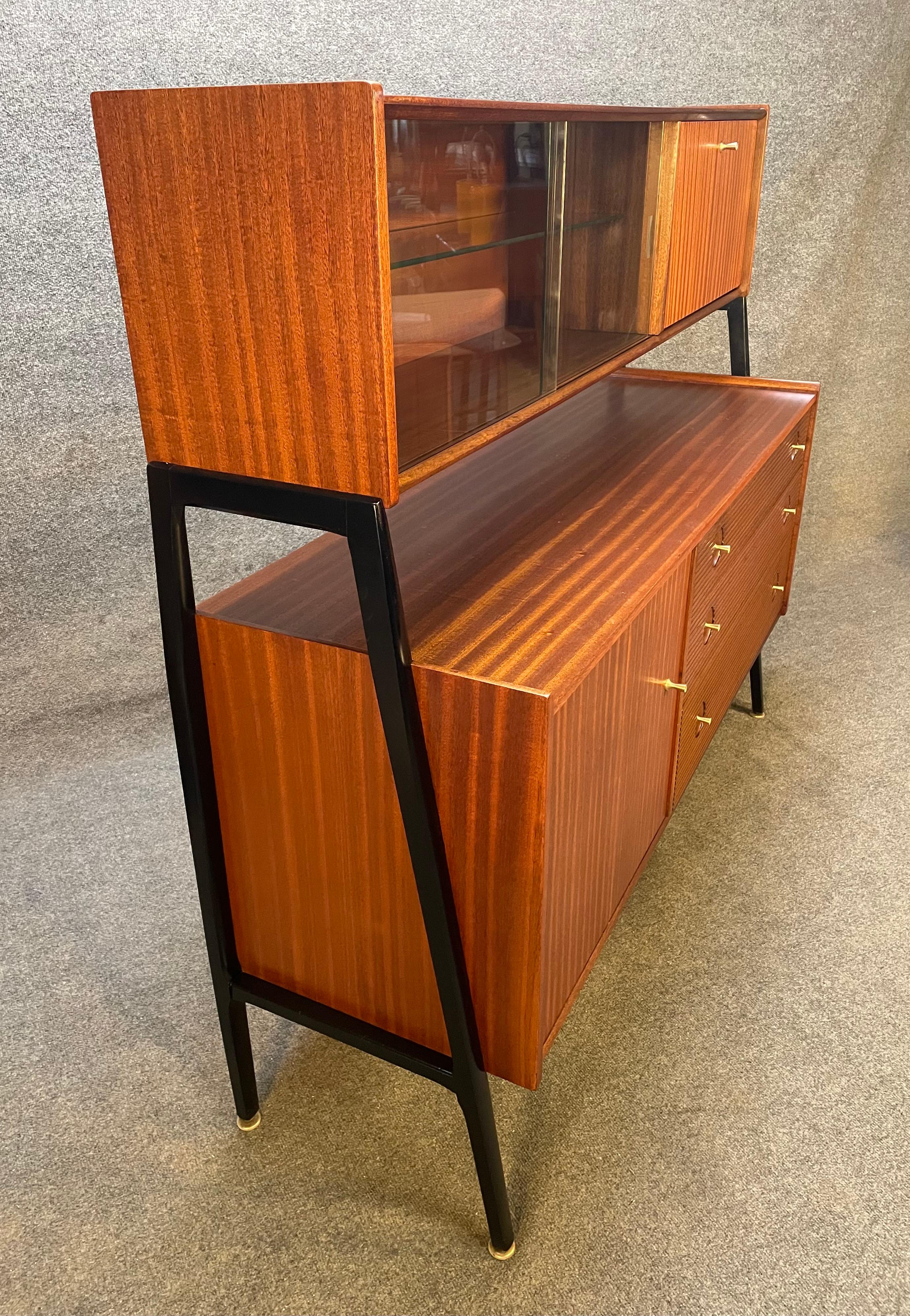 Here is a rare 1960s case piece in cherry wood manufactured in England by Nathan in the 1960s. This special hutch, recently imported from UK to California before its refinishing, features on its top a display cabinet with two glass sliding doors and