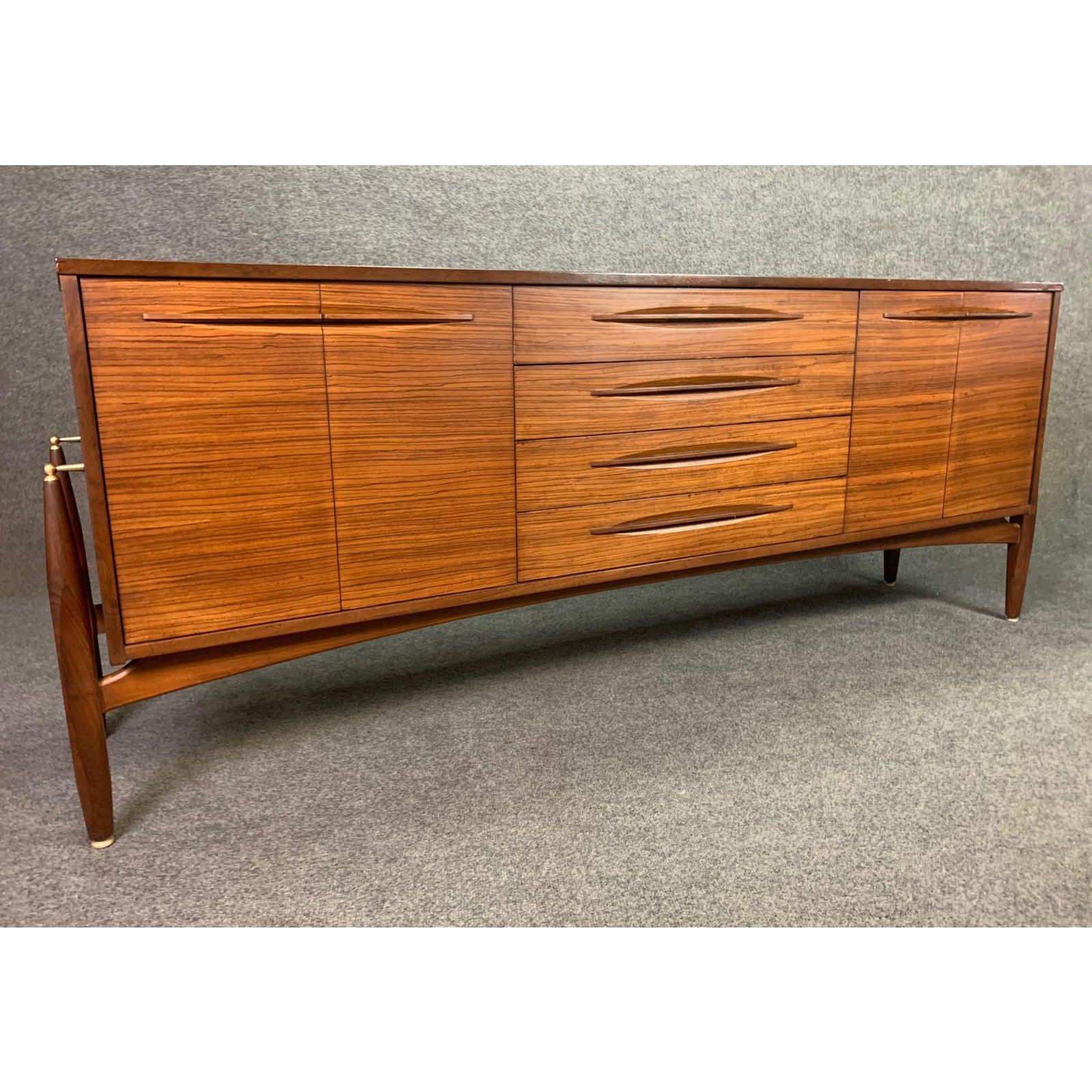 Here is a beautiful MCM sideboard in zebra wood manufactured by Elliotts of Newbury in England in the 1960s.
This lovely credenza was recently imported from UK to California, has been cleaned up, oiled and is in its original condition.
It features
