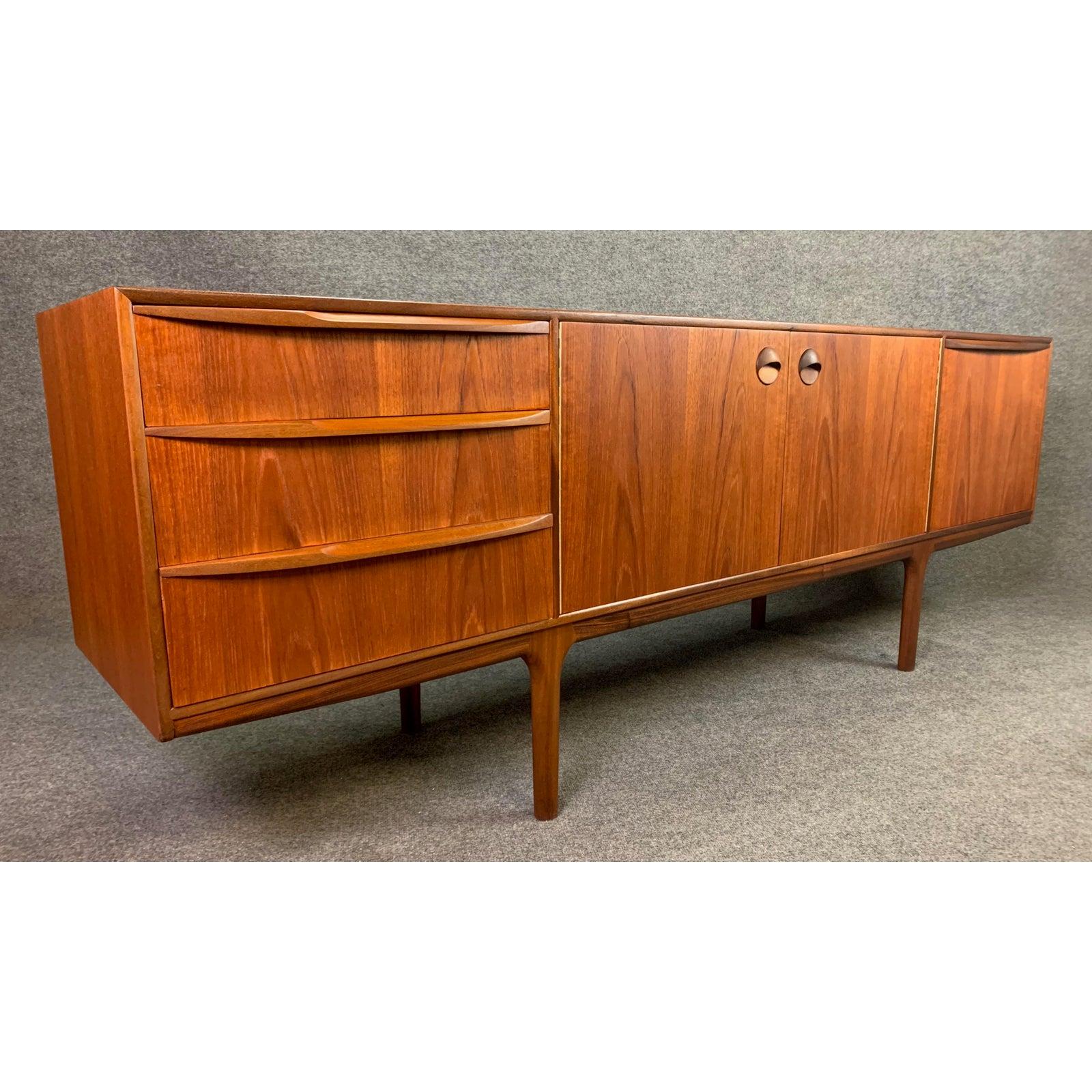 Here is another Classic example of a collectible long teak sideboard designed by Tom Robertson and manufactured by A. H. McIntosh in the 1960s in Scotland. This organically designed credenza features beautiful sculpted handles on each drawers and