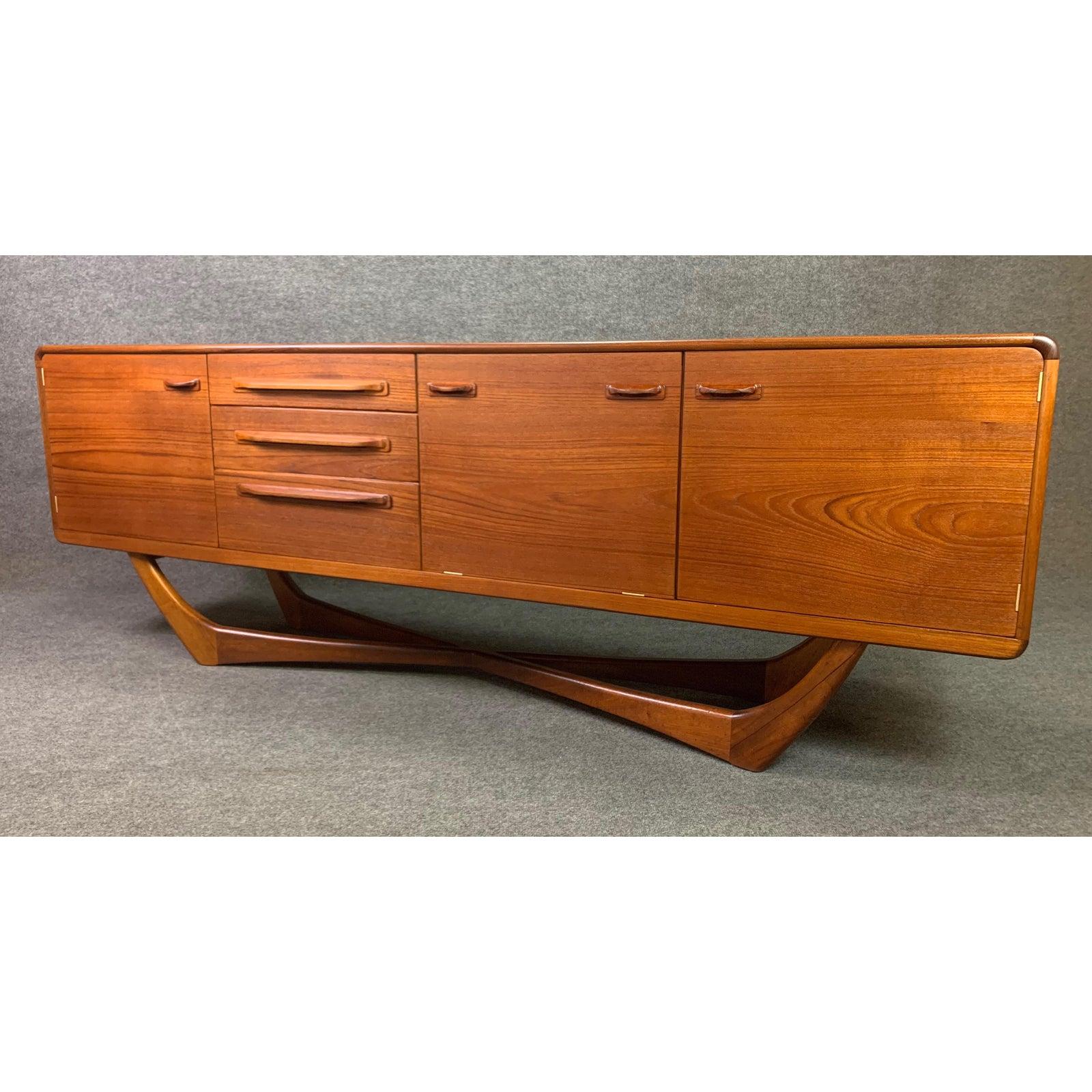 Here is an exceptional Mid-Century Modern sideboard in teak wood manufactured by Beithcraft in Scotland in the 1960s.
This sculptural credenza, recently imported from England to California before its complete refinishing, features a vibrant wood