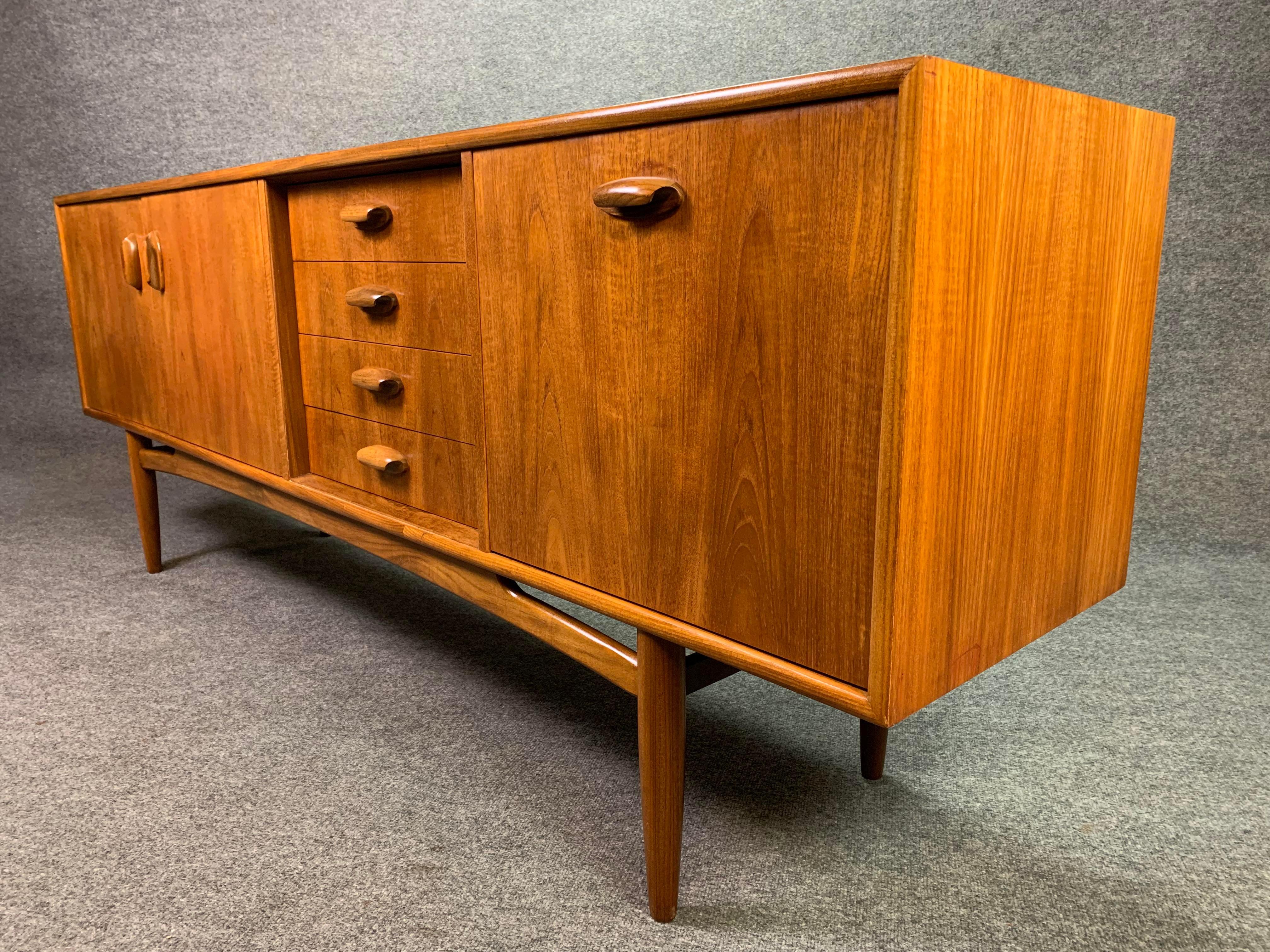 Here is a vintage british modern teak sideboard Circa 1960's designed by Victor Wilkins and manufactured by G plan in England. 
This beautiful case good, recently imported from Europe to California before its refinishing, features a vibrant teak