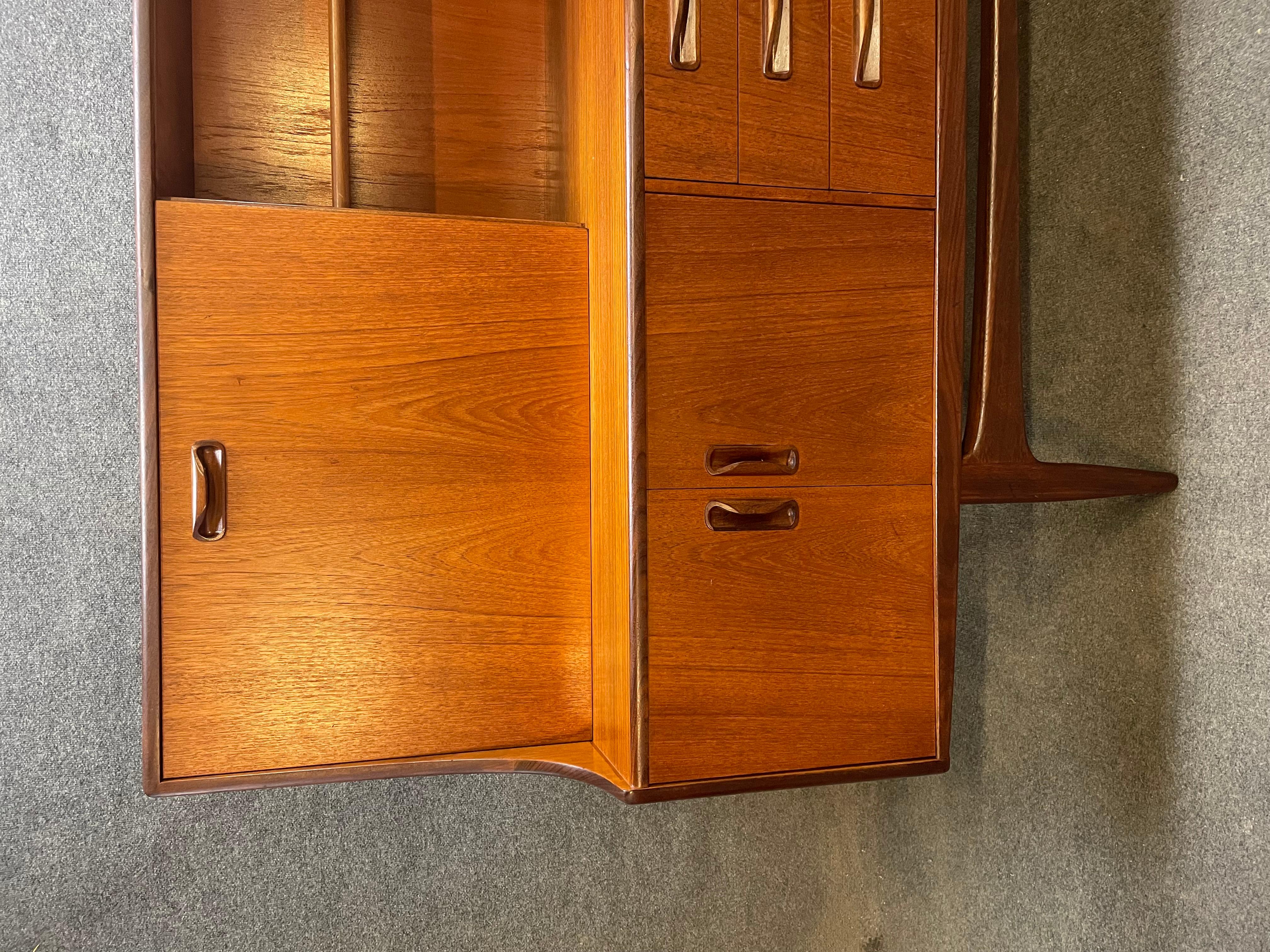 Here is a beautiful British Mid-Century Modern tall sideboard in teak wood designed by Victor Wilkins for the 