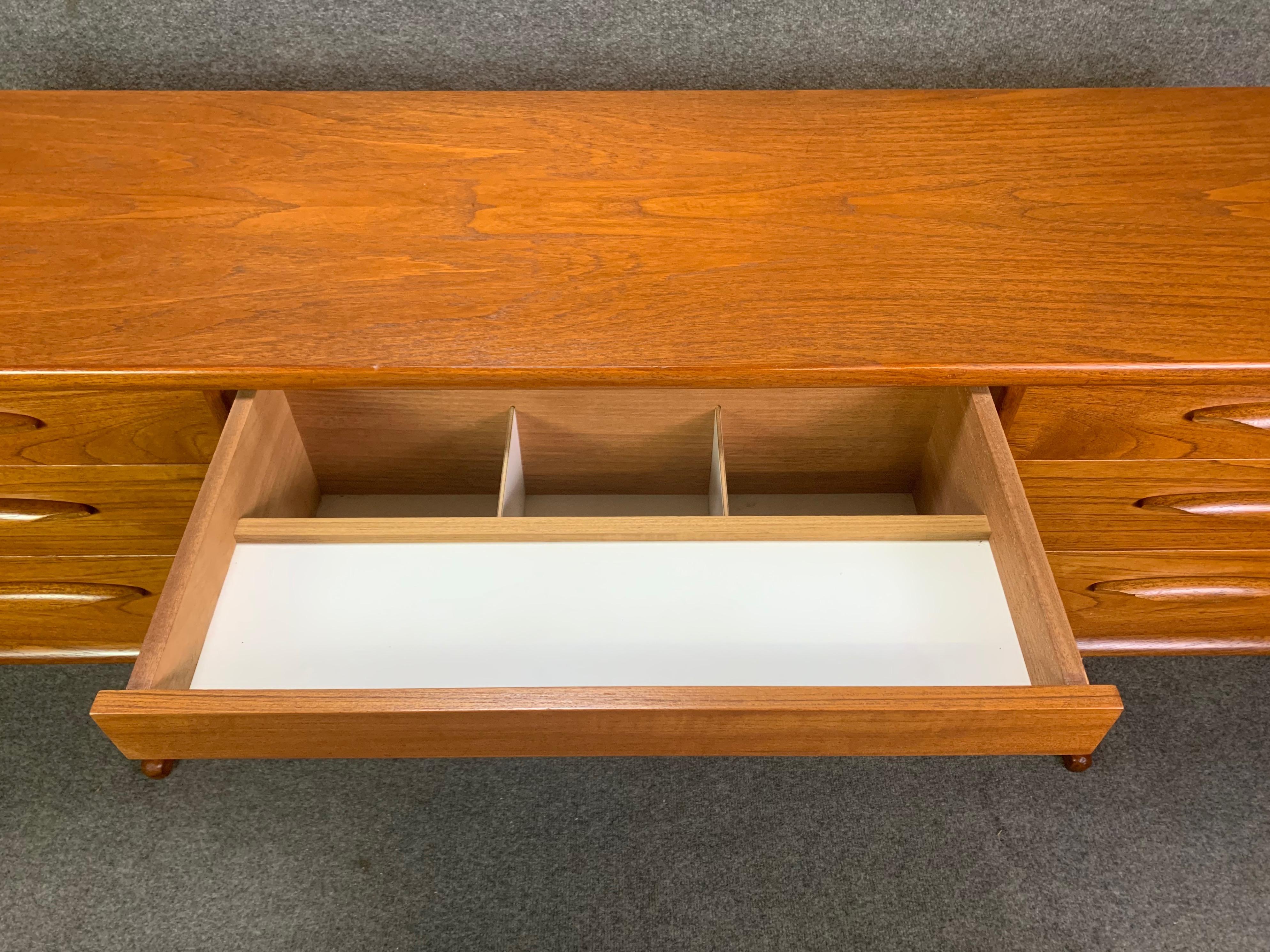 Here is beautiful Mid-Century Modern desk in teak wood designed by Frank Guille and manufactured by Austinsuitein England in the 1960s.
This special piece, recently imported from the UK to California, features a vibrant wood grain, seven drawers