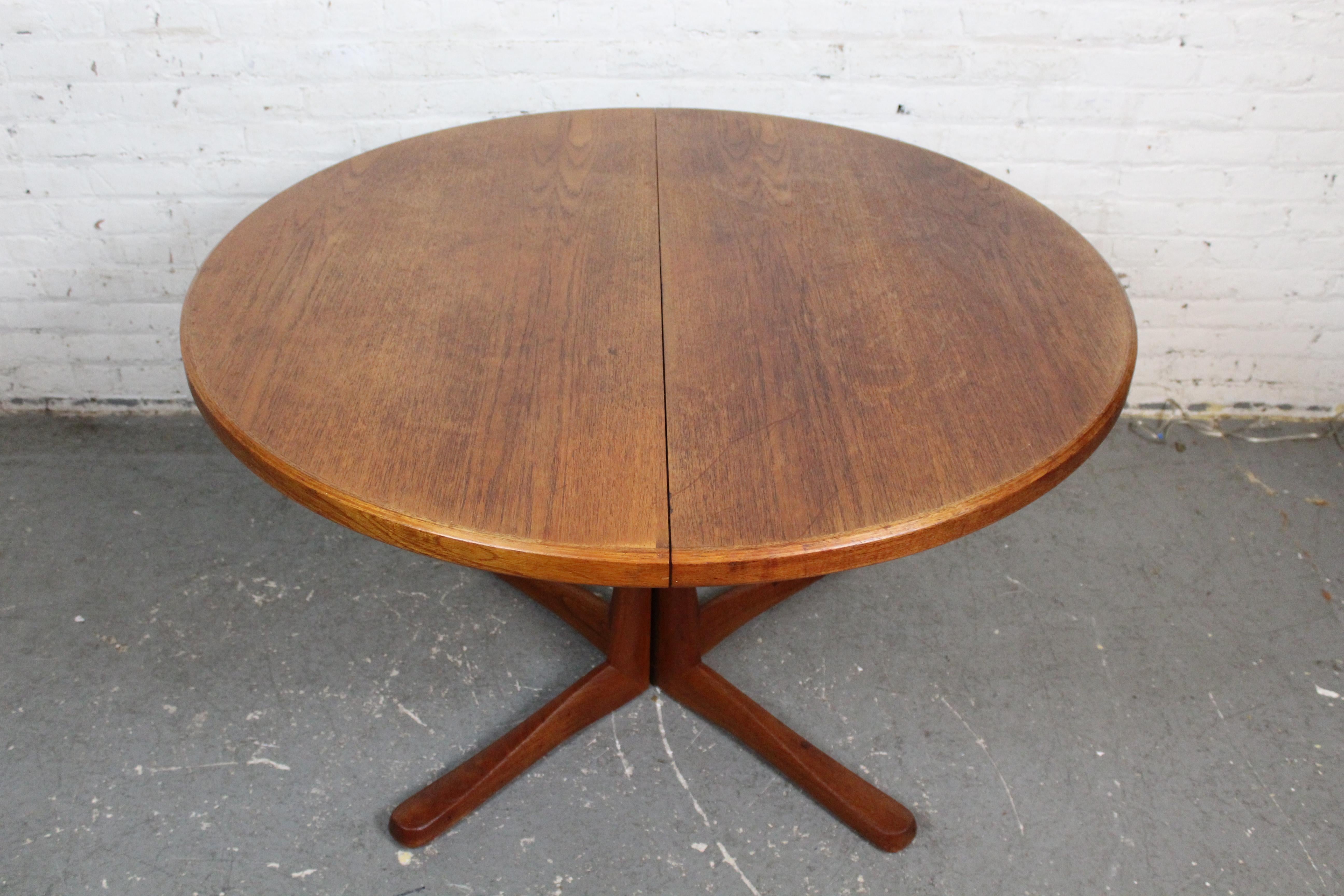 Enhance your dining experience with this exquisite mid-century British Modern pedestal table attributed to Scotland's A.H. McIntosh of Kirkcaldy. Boasting teak construction and subtly elegant carved V-legs, this 48