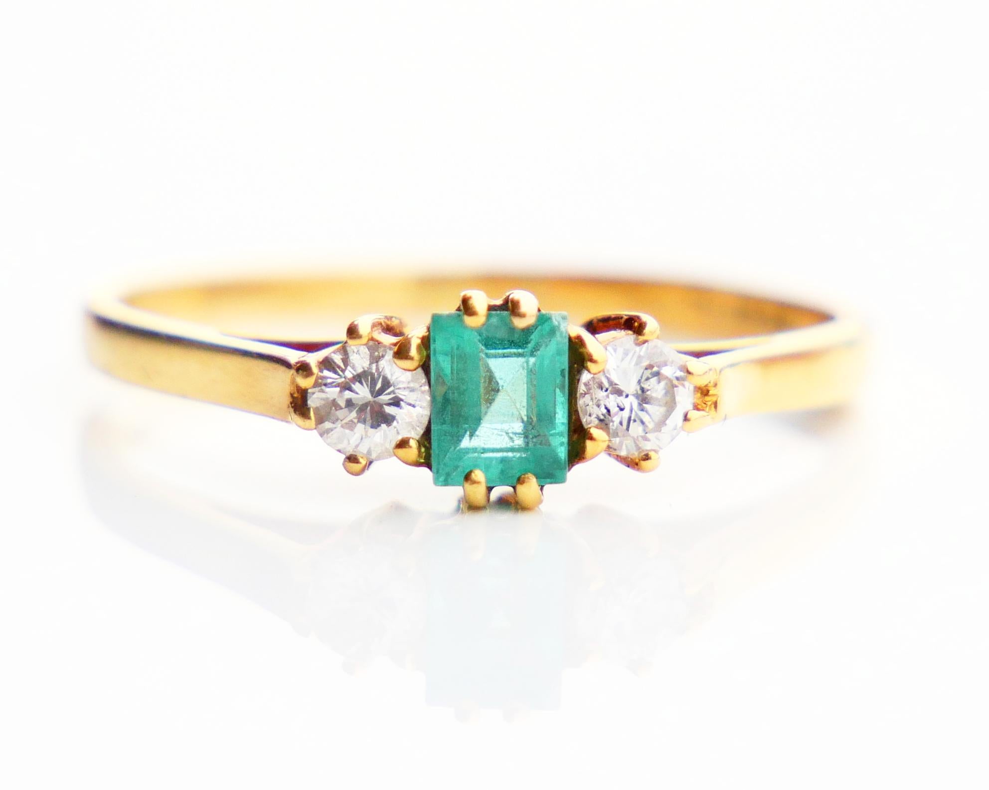 
Vintage 3 stones ring with plain band in solid 18K Yellow Gold.

Crown is 5 mm deep . Claw set natural Emerald cut 5.5 mm x 4 mm / ca. 05 ct flanked with two old diamond cut Diamonds in claws Ø 3.5 mm / 0.17 ct. each stone, color G,H /VS . Stones