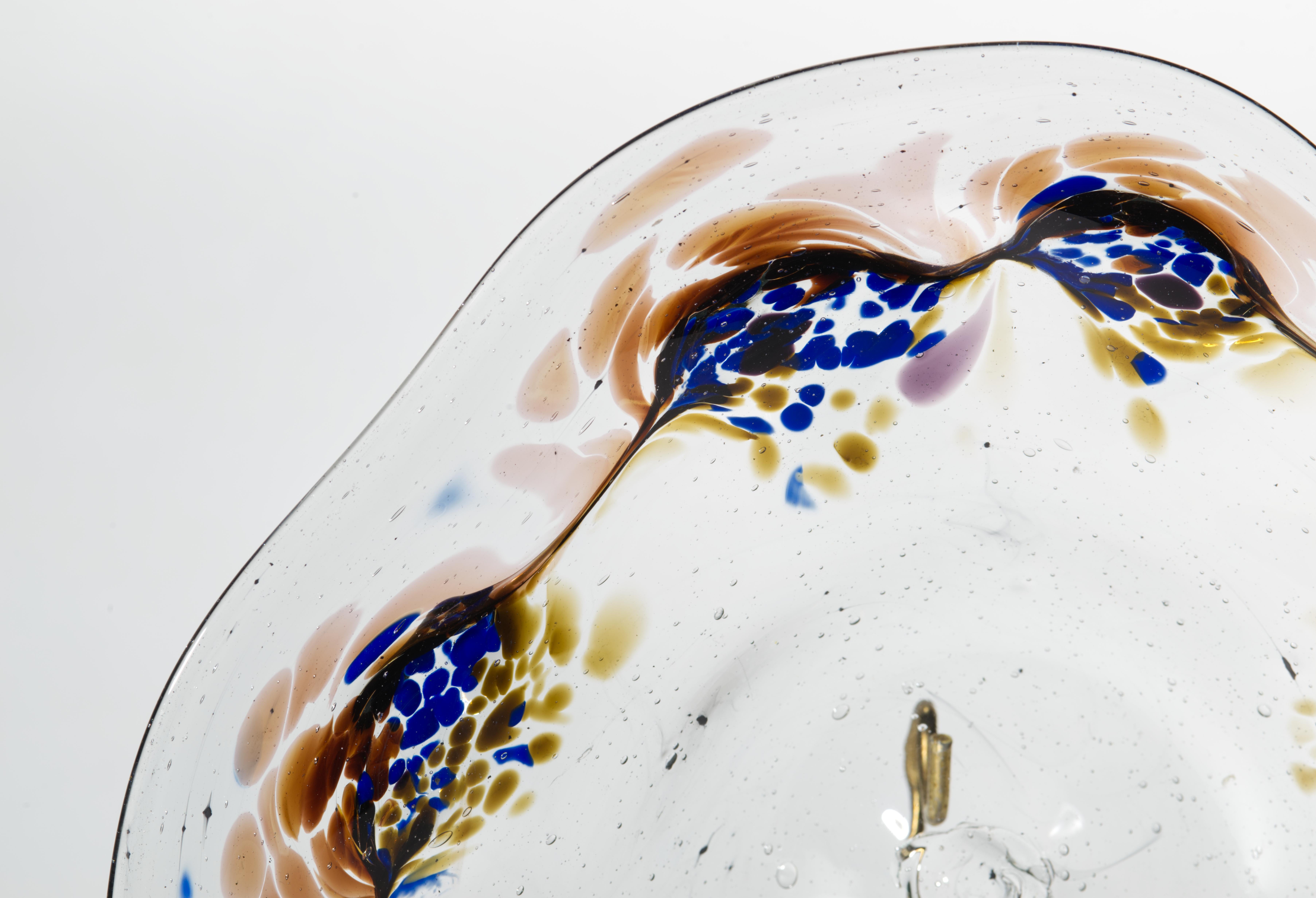  Pauline Solven’s blown and applied glass bowl features asymmetrical, free-flowing rim and cobalt blue and soft mocha brown fused applied glass band, reminiscent of blooming flowers. The inclusion of small controlled bubbles in the clear glass layer
