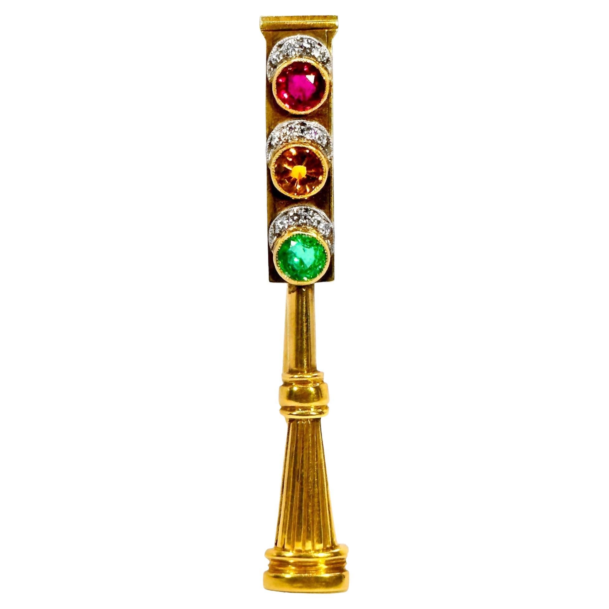 This wonderful early 20th century British 18 karat yellow gold pole mounted traffic control light brooch is a nostalgic visual delight. Three bright round gems, a ruby, emerald and golden citrine are control indicators. Each has a hood of brilliant