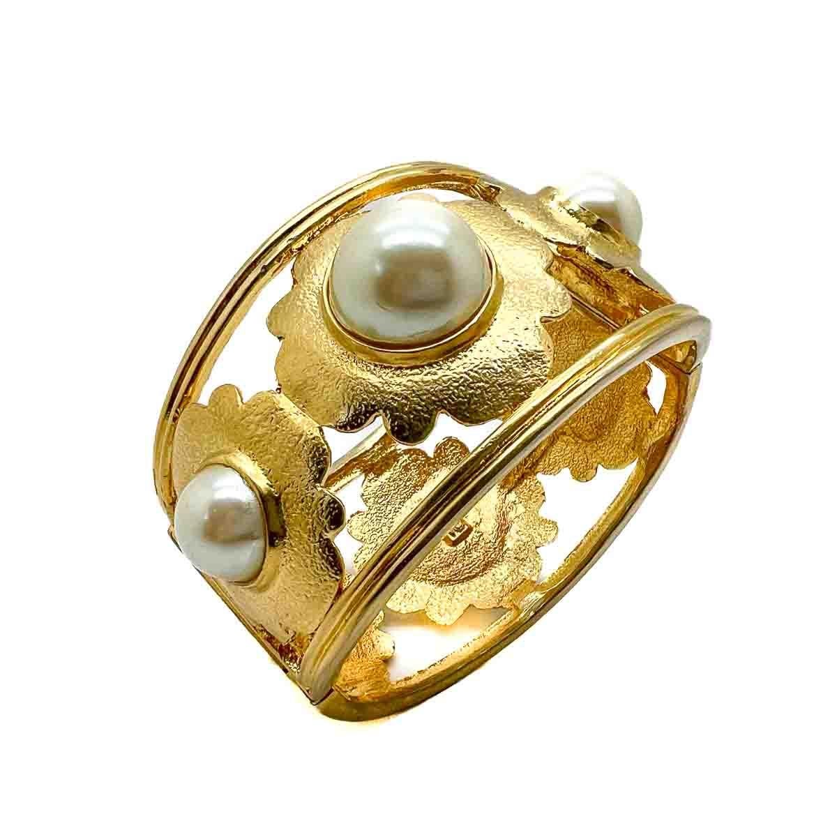 A Vintage Pearl Floral Motif Cuff. Reminiscent of the Chanel designs of the time, this bold cuff flaunts it elegantly timeless combination of rich gold and lustrous pearl to perfection. A timeless classic that will undoubtedly up your style