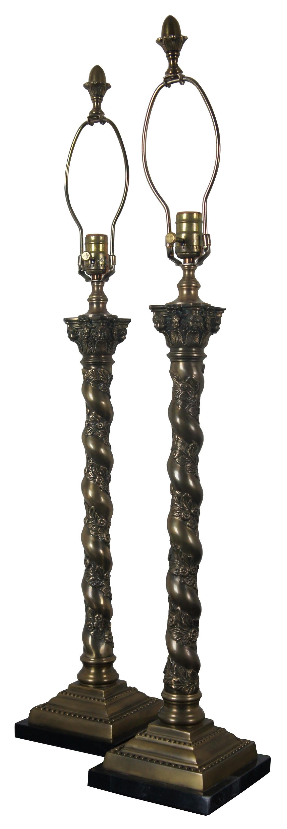 Vintage bronze barley twist lamp pair attributed to Theodore Alexander. Features Corinthian columns with cherubs or pooties on marble base with acorn finials and floral motif. Very heavy. Measures: 37”.