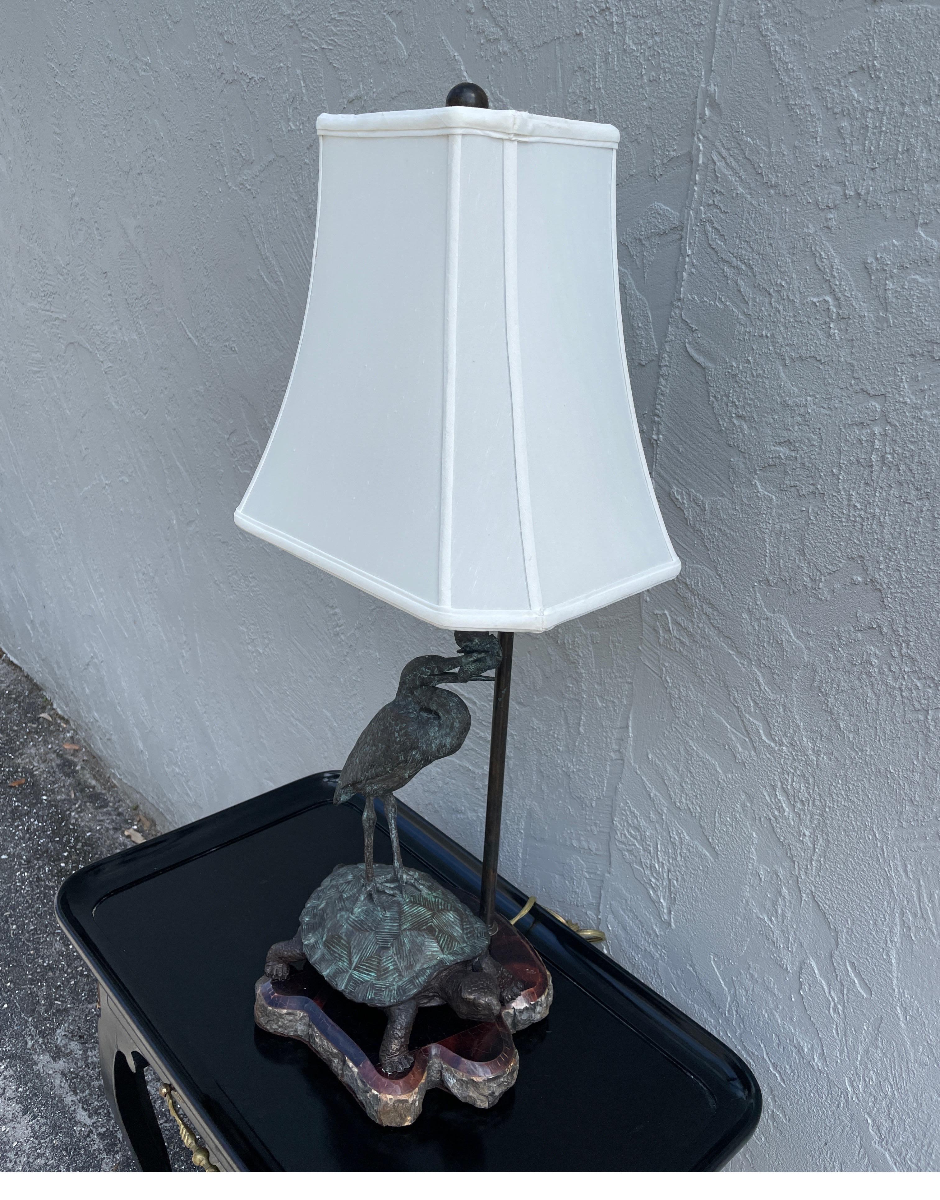 Bronze table lamp depicting a bird standing on a turtle. Base is a free form shape covered in pen shell.