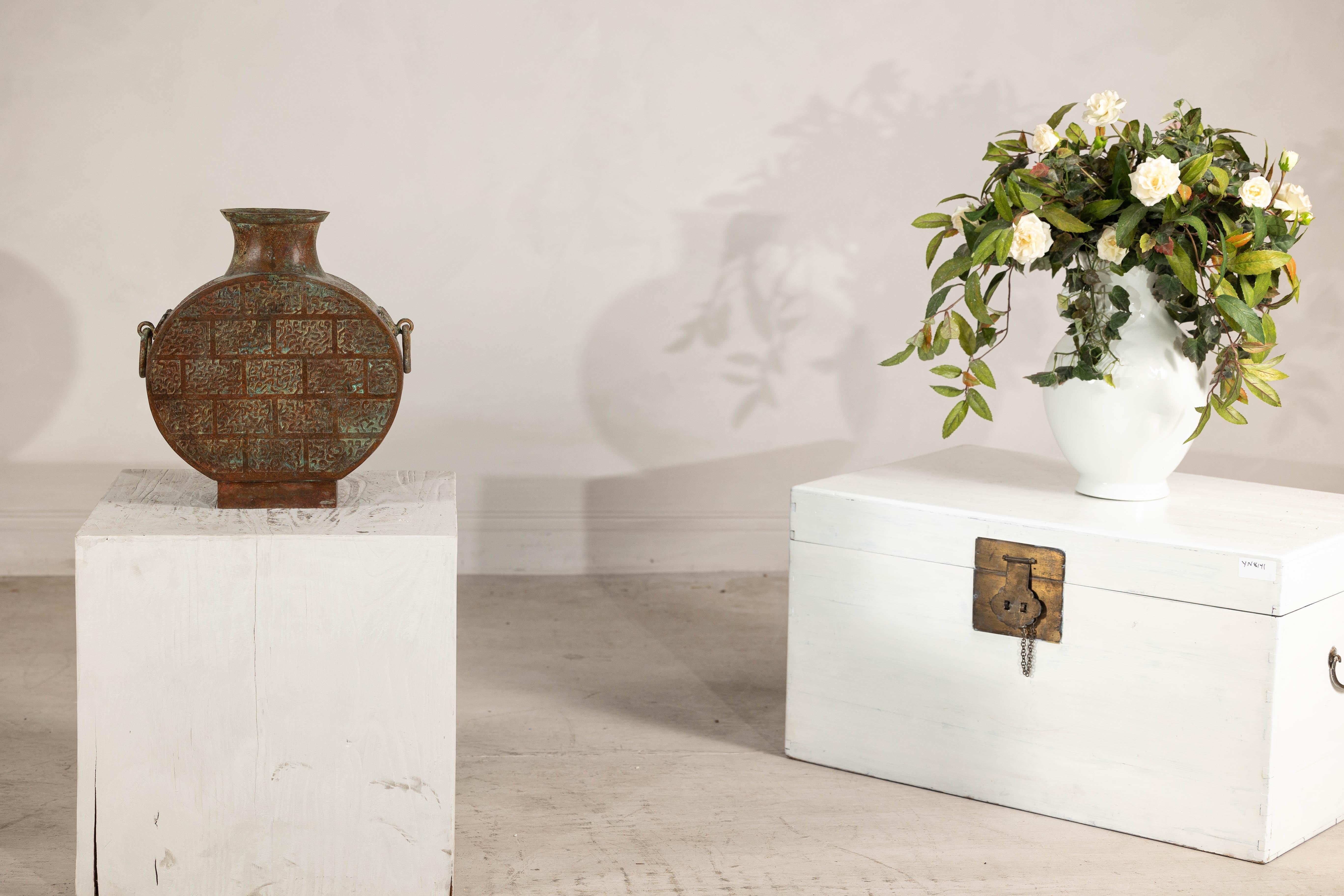 Realizzata nell'intramontabile stile della dinastia Han, questa bottiglia vintage in bronzo incarna l'eleganza e la maestria dell'antica Cina. Il corpo circolare appiattito poggia su una base robusta, mentre intricati disegni incisi ricoprono la