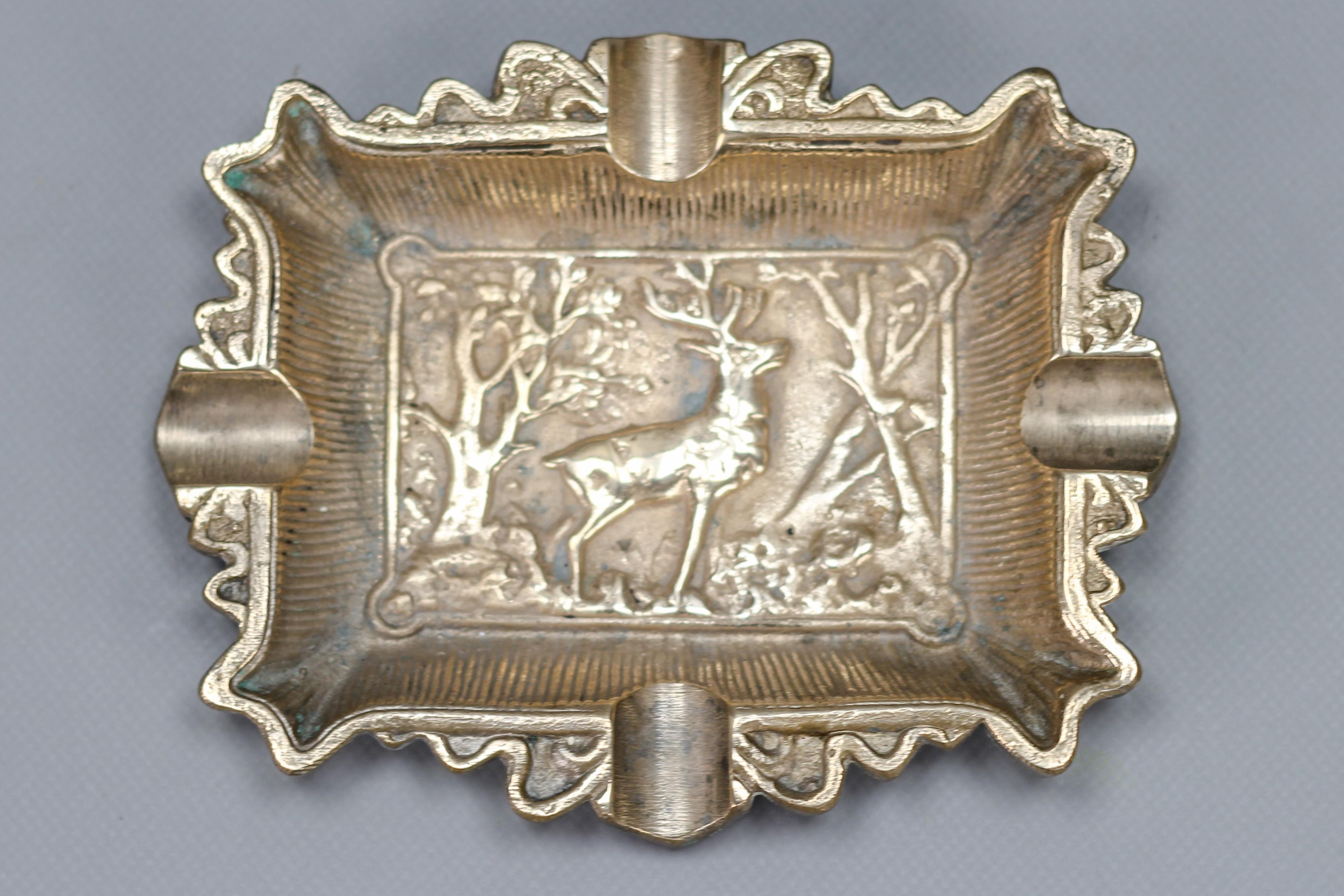 Vintage bronze cigar ashtray with a stag deer relief, the 1950s.
This elegant hunting-theme bronze cigar ashtray features a central relief panel that depicts a stag deer surrounded by trees. 
Dimensions: height: 2 cm / 0.78 in; width: 15.5 cm /