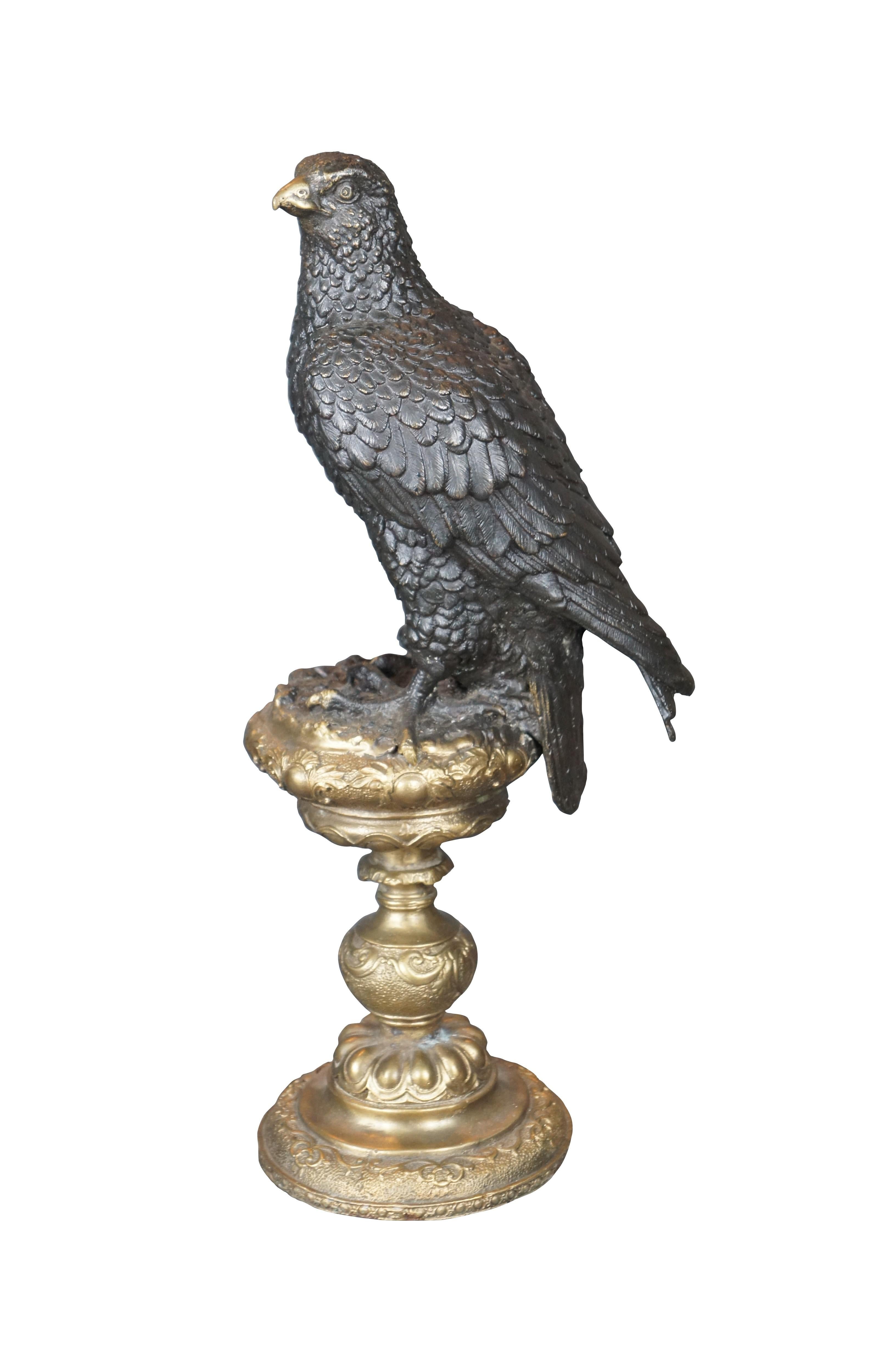 An impressive bronze eagle over an altar stick after Archibald Thorburn (Scottish 1860-1935). Features a bronze figure of a perched golden eagle. The eagle is in black with a gold beak over an ornate gold finished pedestal / altar stick. A beautiful