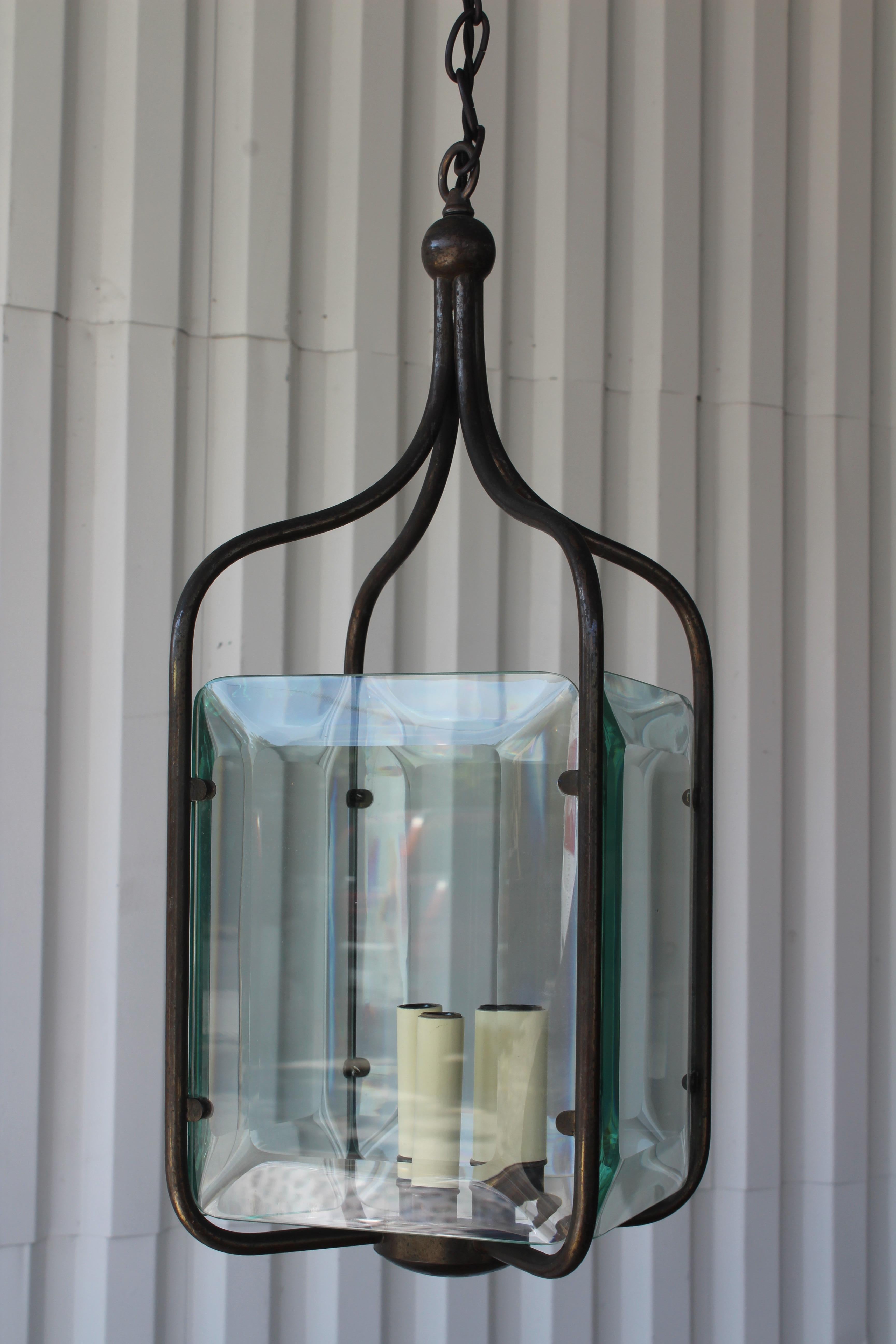 Vintage bronze hanging pendant with four glass panels. Newly rewired and new beveled glass panels which matched the original. Fitted for three candelabra 60W bulbs. In excellent condition with a nice patina to the bronze. Total length from canopy to