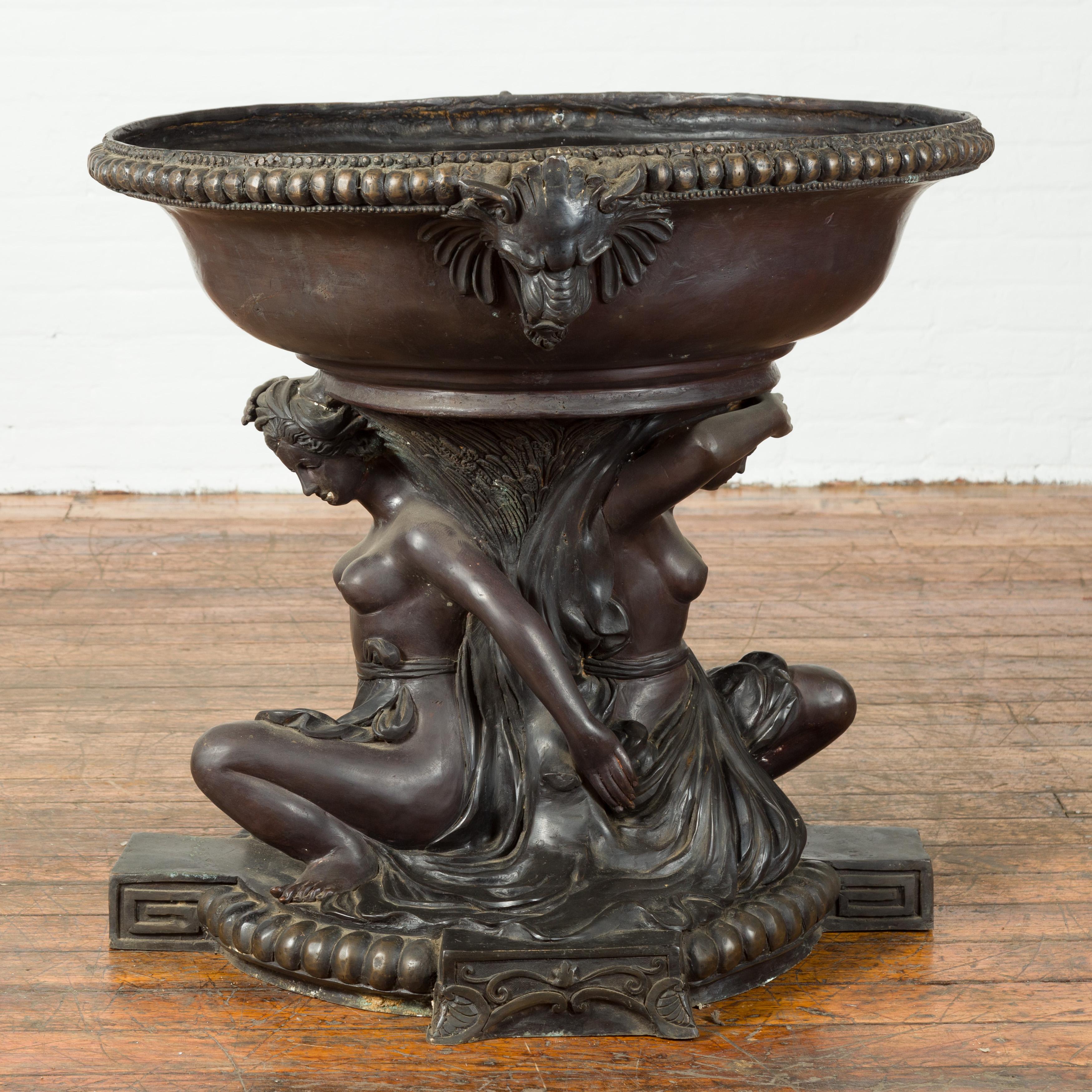 A vintage bronze Greco-Roman style Allegory of the Summer planter from the mid 20th century, with dark patina and lion heads. Created with the traditional technique of the lost-wax (à la cire Perdue) which allows for great precision and finesse in