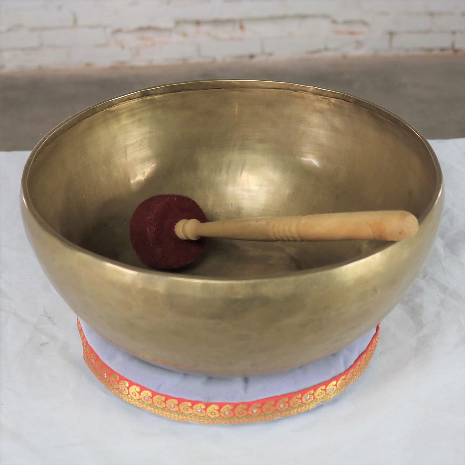 Beautiful singing bowl or standing bowl with a mallet and its playing pillow. Handmade of bronze or bell metal and showing the makers hand. It is in wonderful vintage condition with awesome patina. Please see photos, circa 20th century.

This is