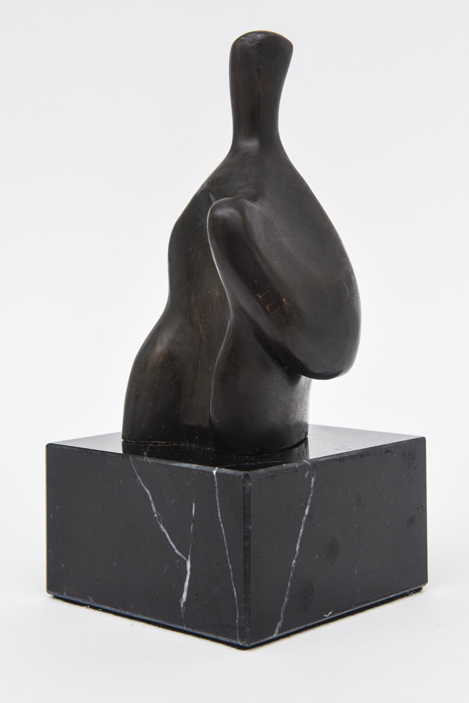 This unique vintage bronze abstract figurative sculpture is on a black veined marble base it is not numbered. The style is very much reminiscent and influence of a Henry Moore. Great small tabletop sculpture as a desk accessory or cocktail table.