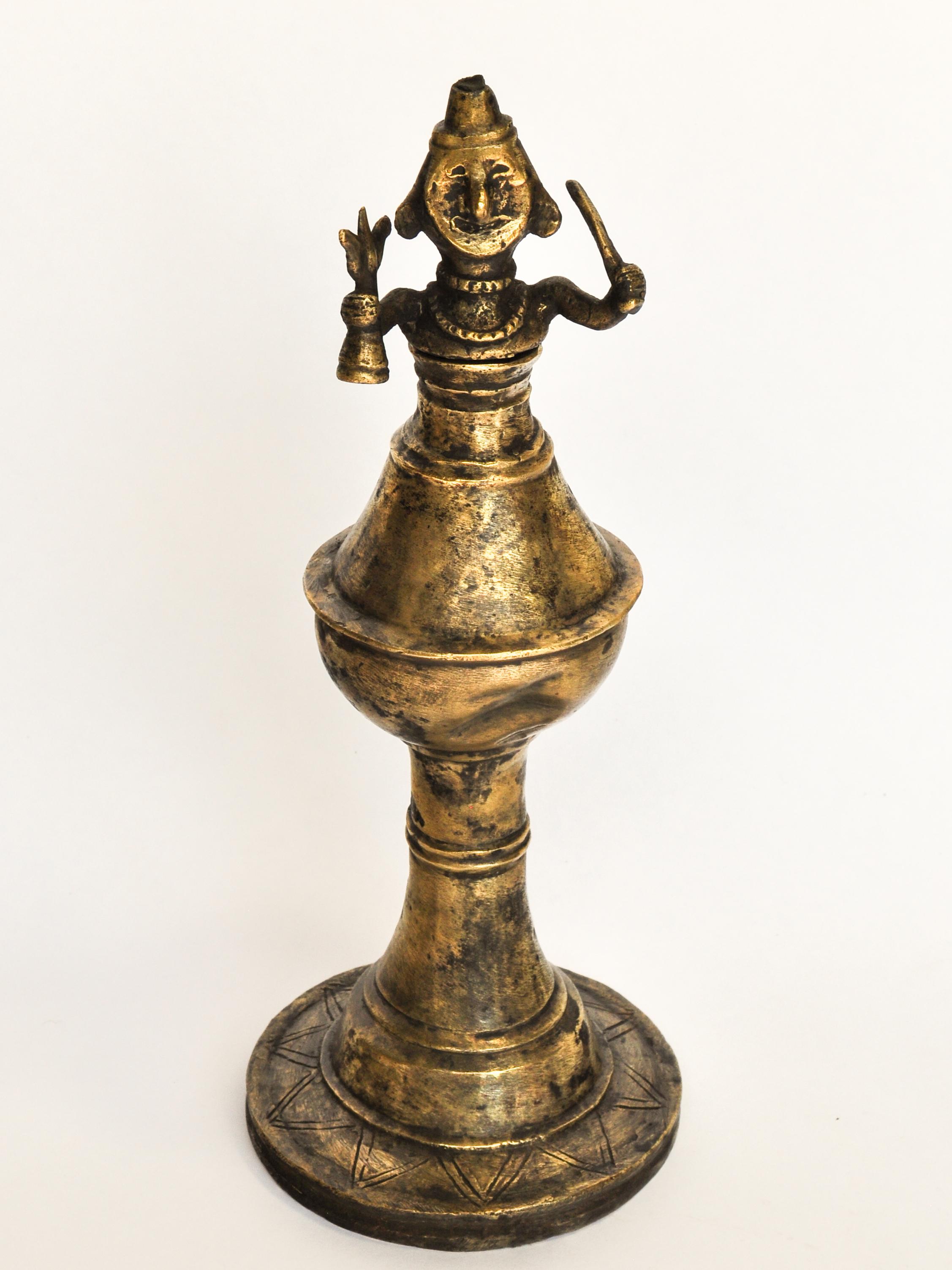 Vintage bronze oil lamp with Shaman figure from West Nepal. Mid-20th Century. 11 inches tall.
This lamp comes from far west Nepal, an off the beaten path area known for its sculptures and cult practices involving shamans and ritualized trance. The