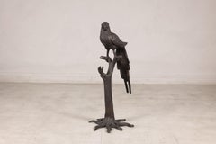 Escultura vintage de un loro de bronce sobre un soporte con forma de rama