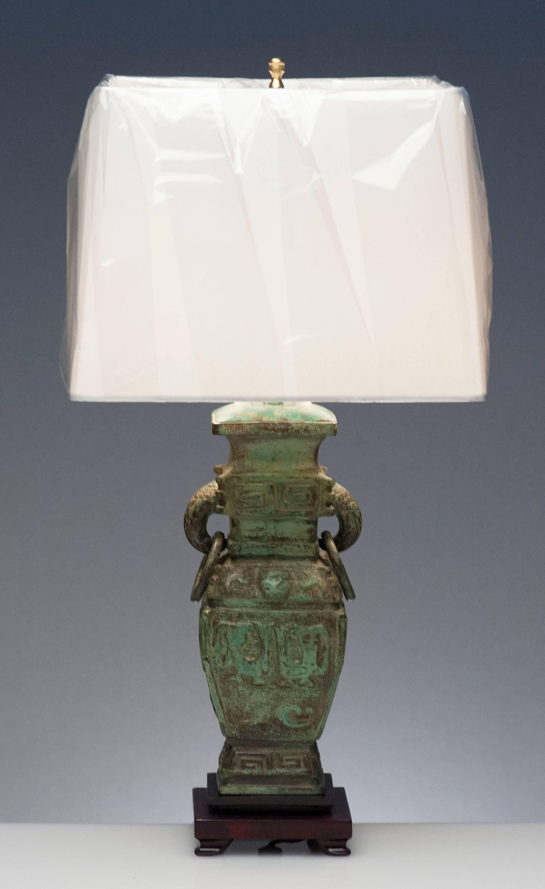 Attrayante et lourde lampe de table asiatique en bronze. Magnifique patine bleu vert. La base est en bois de rose et la hauteur de l'abat-jour est réglable. La lampe est bien faite et est livrée complète avec un nouvel abat-jour en soie. La base en