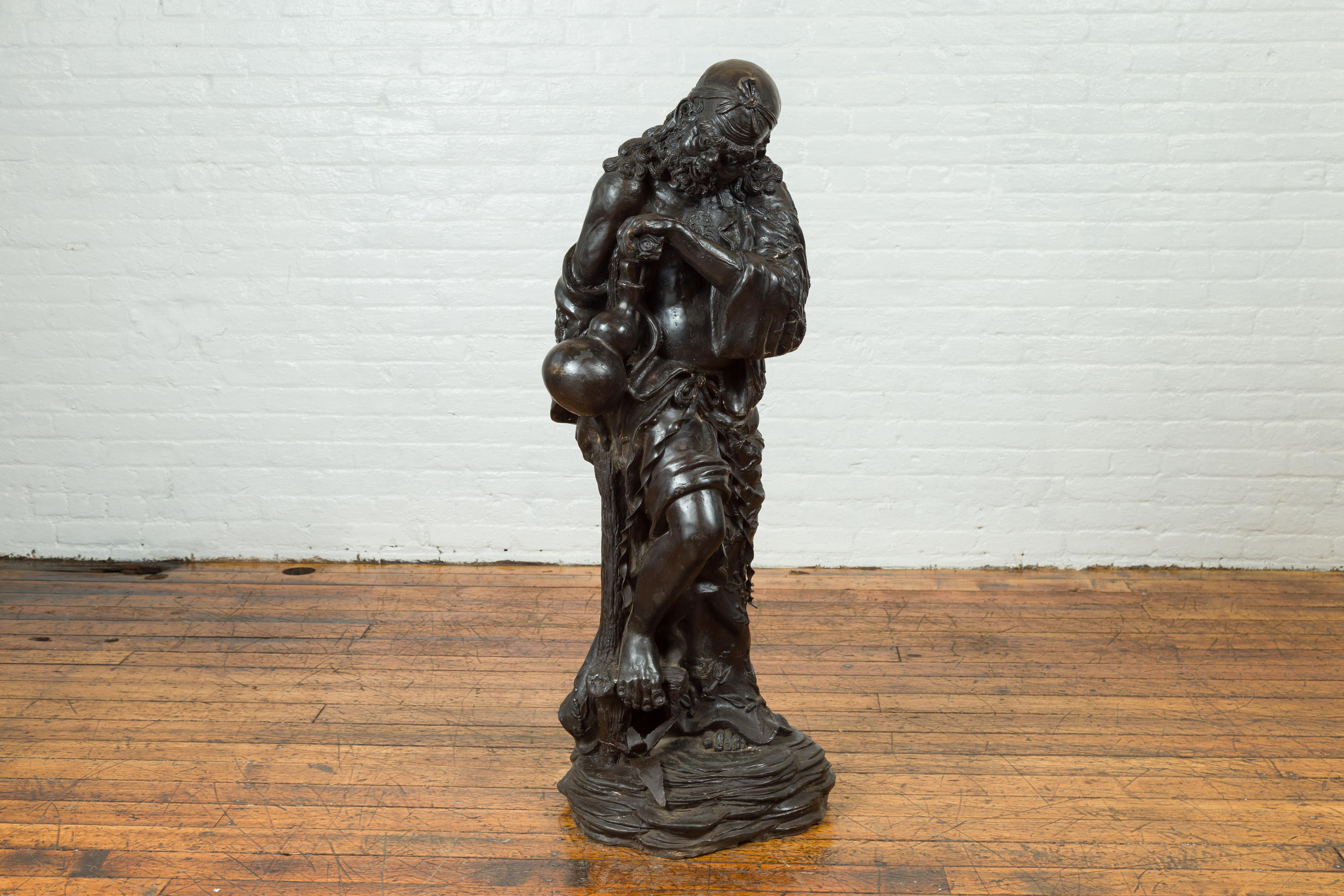 A vintage bronze sculpture from the mid-20th century, depicting a mythical warrior holding a flask. Created with the traditional technique of the lost-wax (à la cire perdue) that allows a great precision in the details, this bronze sculpture