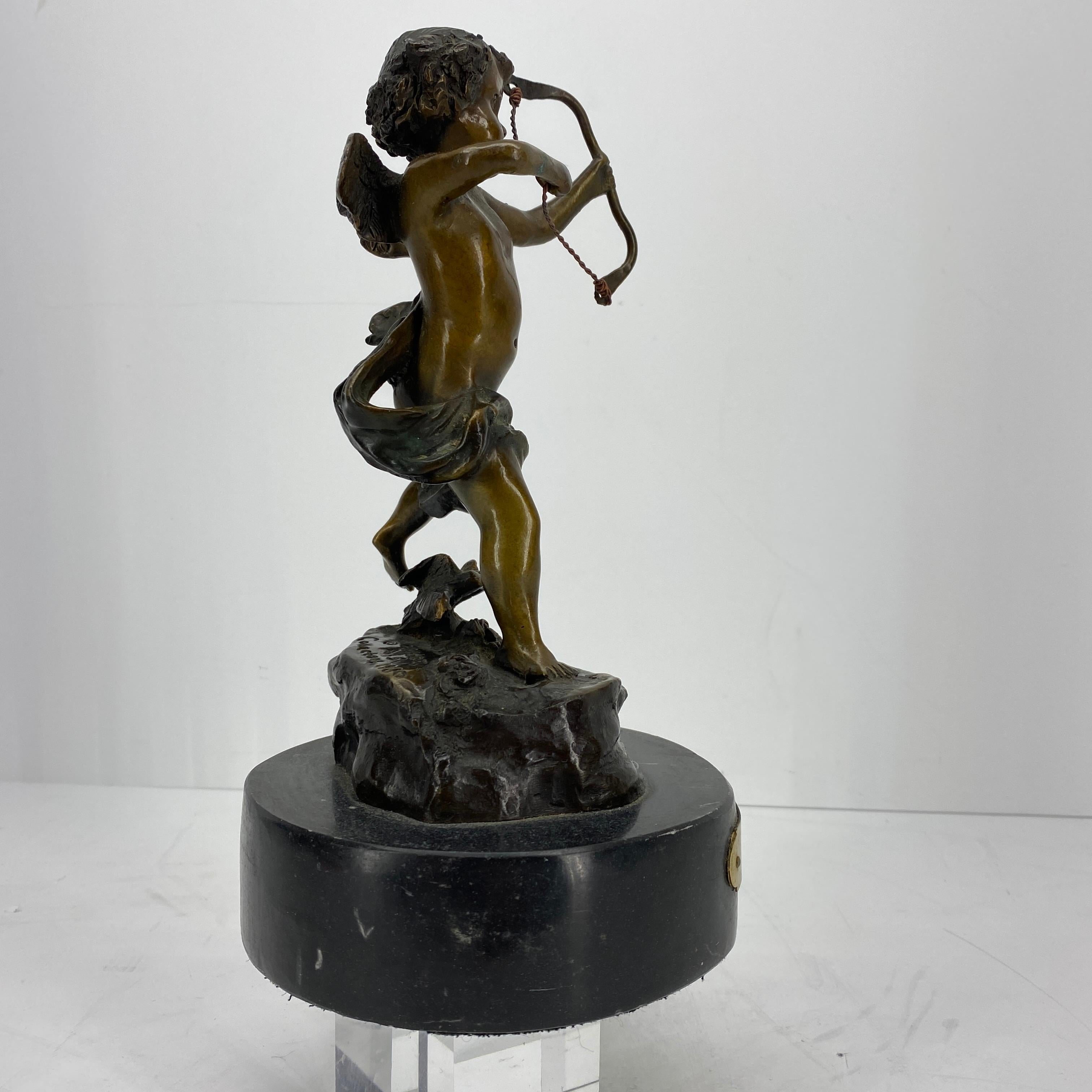 Small bronze cupid sculpture after models from Houdon, dated 1980. Sculpture is based on a thick black marble base.