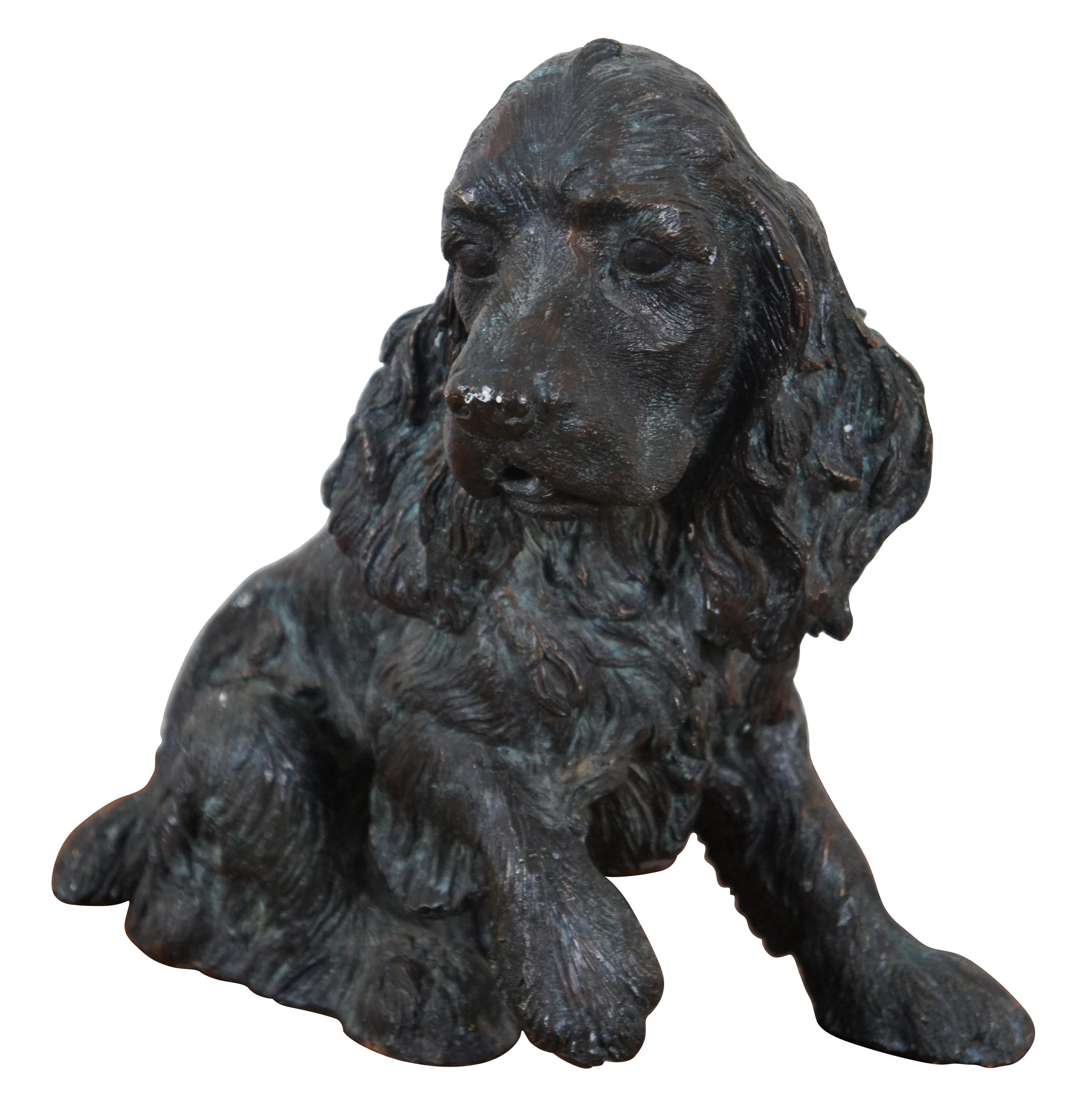 Finely detailed vintage bronze sculpture / statuette of a seated Cocker Spaniel or Irish Setter with one paw raised.