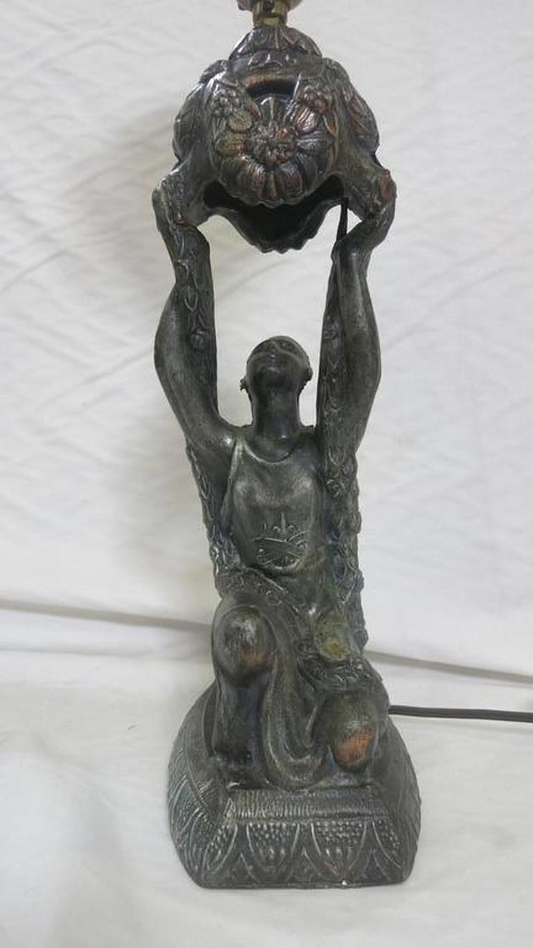 Art Deco table lamp. Bronze style Spelter Joan of Arc holding up a bouquet, kneeling on a pedestal by La Belle.

Dimensions: 23