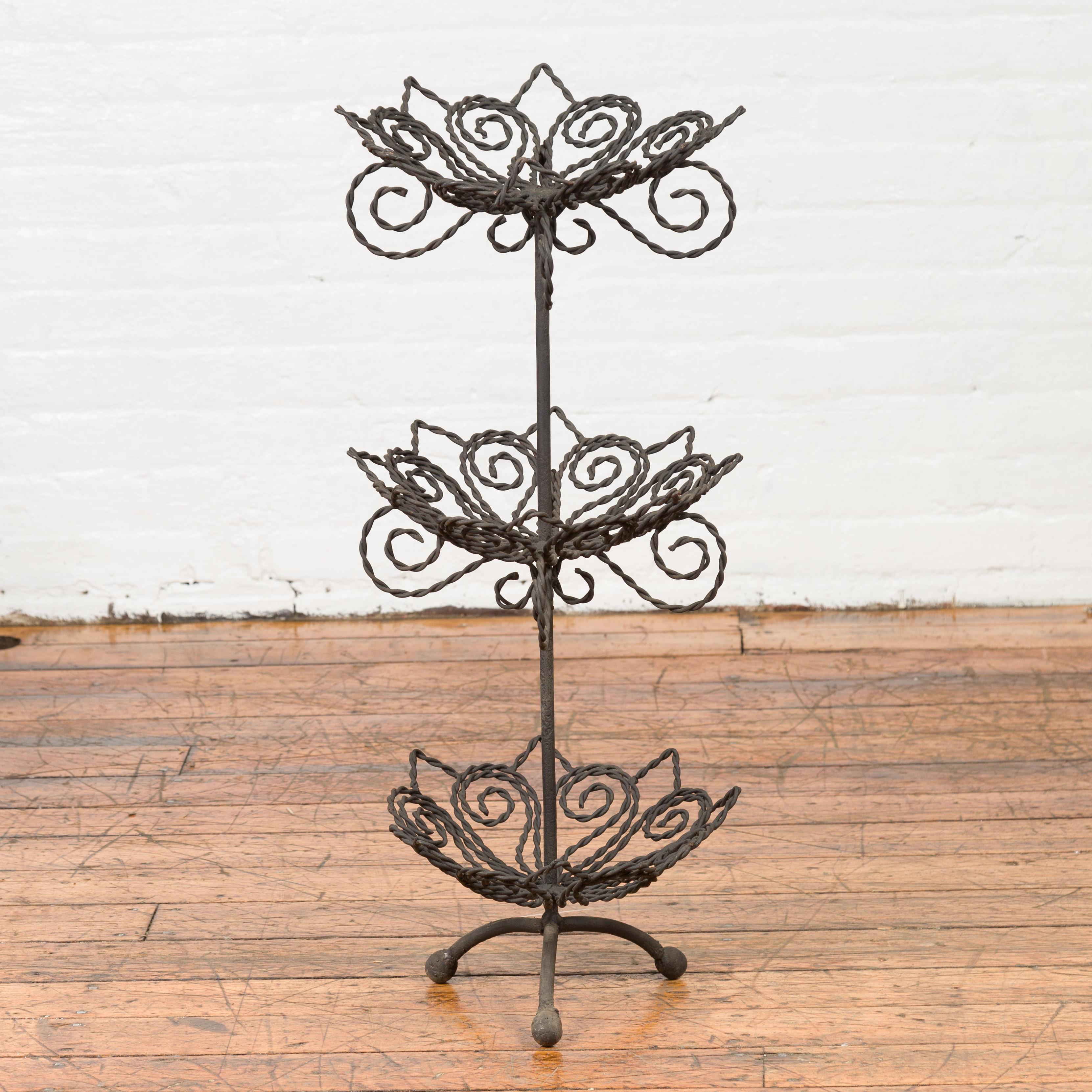 A vintage bronze three-tiered stand from the mid-20th century, with scrolled motifs. Created with the traditional technique of the lost-wax (à la cire perdue) that allows a great precision and finesse in the details, this tiered stand features three
